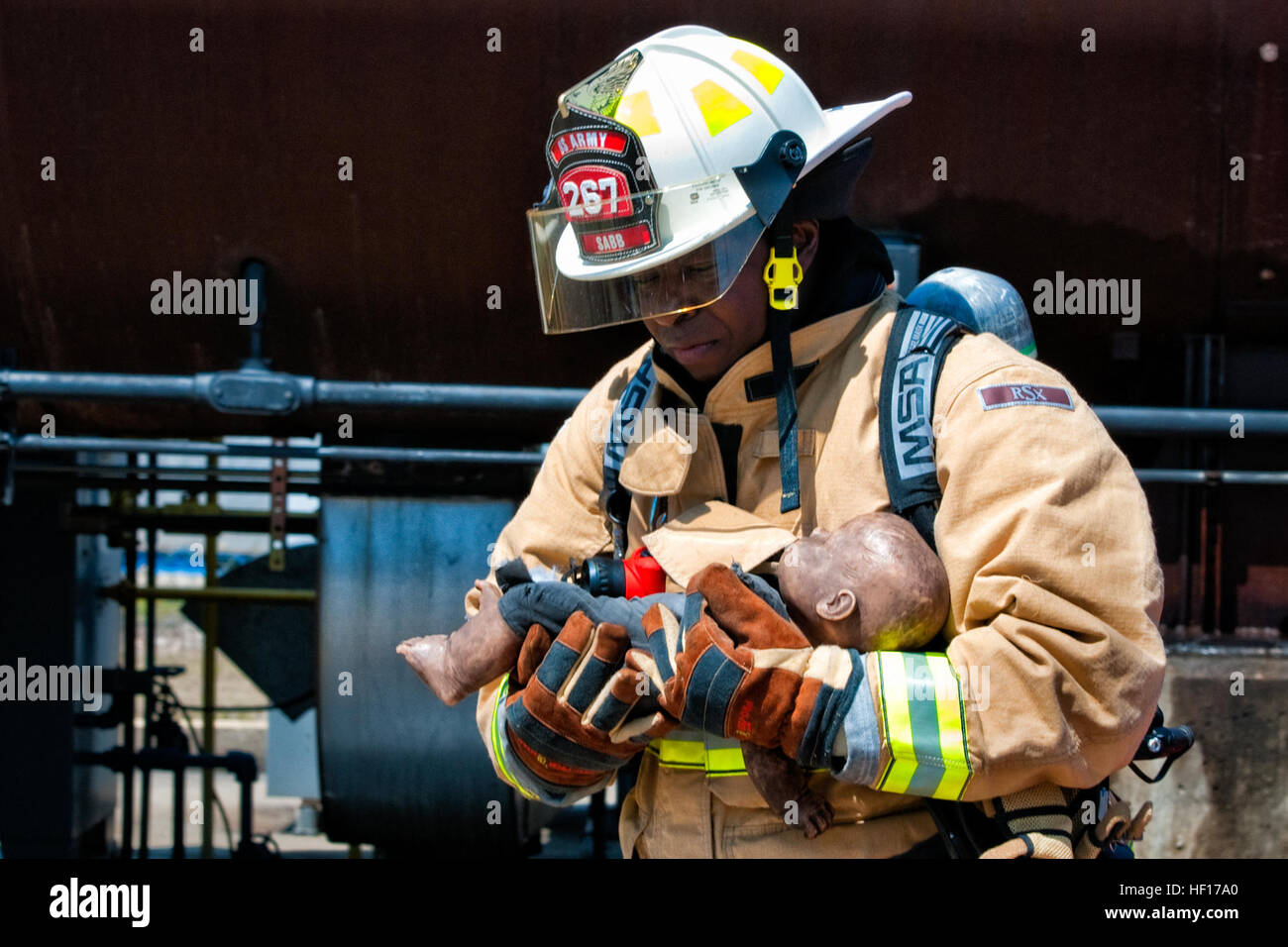 Stati Uniti Il personale dell'esercito Sgt. Ricky Sabb, 267Engineer distacco (lotta antincendio), detiene una simulazione del neonato durante un aeromobile recuse scenario di estinzione alla S.C. Fire Academy, Columbia, S.C., Marzo 29, 2013. Sabb è il recupero di vittime al di fuori di un simulato 737 aeromobili scenario di incidente. (U.S. Air Force photo by Staff Sgt. Jorge Intriago/RILASCIATO) SC Guardia Nazionale ingegnere distacco (Vigili del Fuoco) 130329-Z-XH297-055 Foto Stock