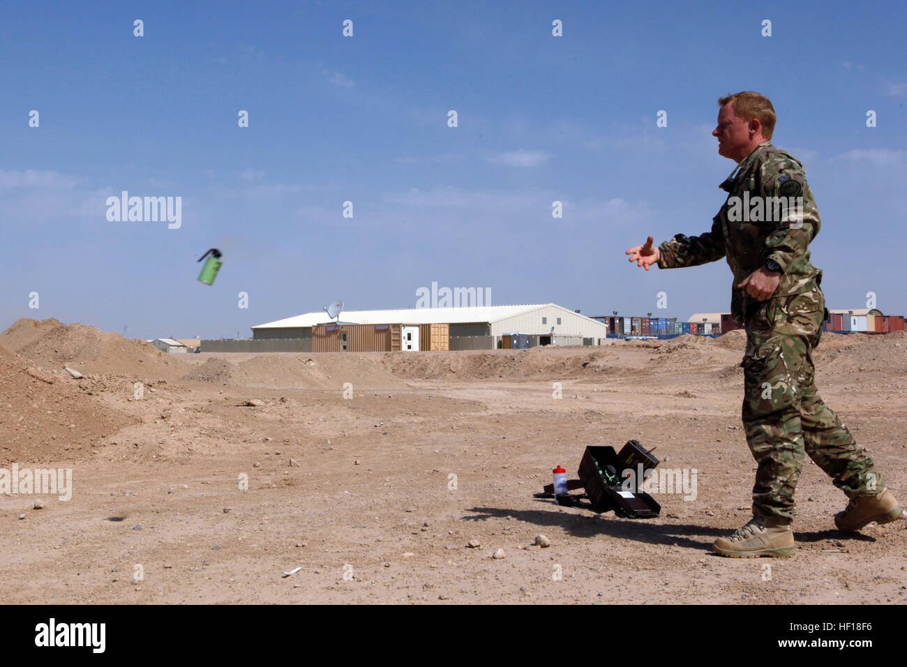 British Royal Air Force Flight Lt. Clemente Cornish, una sicurezza di volo ufficiale con 903 Expeditionary Air Wing, Lancia una granata di fumo durante un esercizio a Camp Leatherneck, provincia di Helmand, Afghanistan, 27 aprile 2013. L'esercizio è stata condotta per mantenere i membri del servizio preparati in caso di aerei abbattuti. (U.S. Marine Corps foto di Cpl. Ashley E. Santy/RILASCIATO) 2D MAW (FWD) conduce custode di formazione soccorso 130427-M-BU728-024 Foto Stock