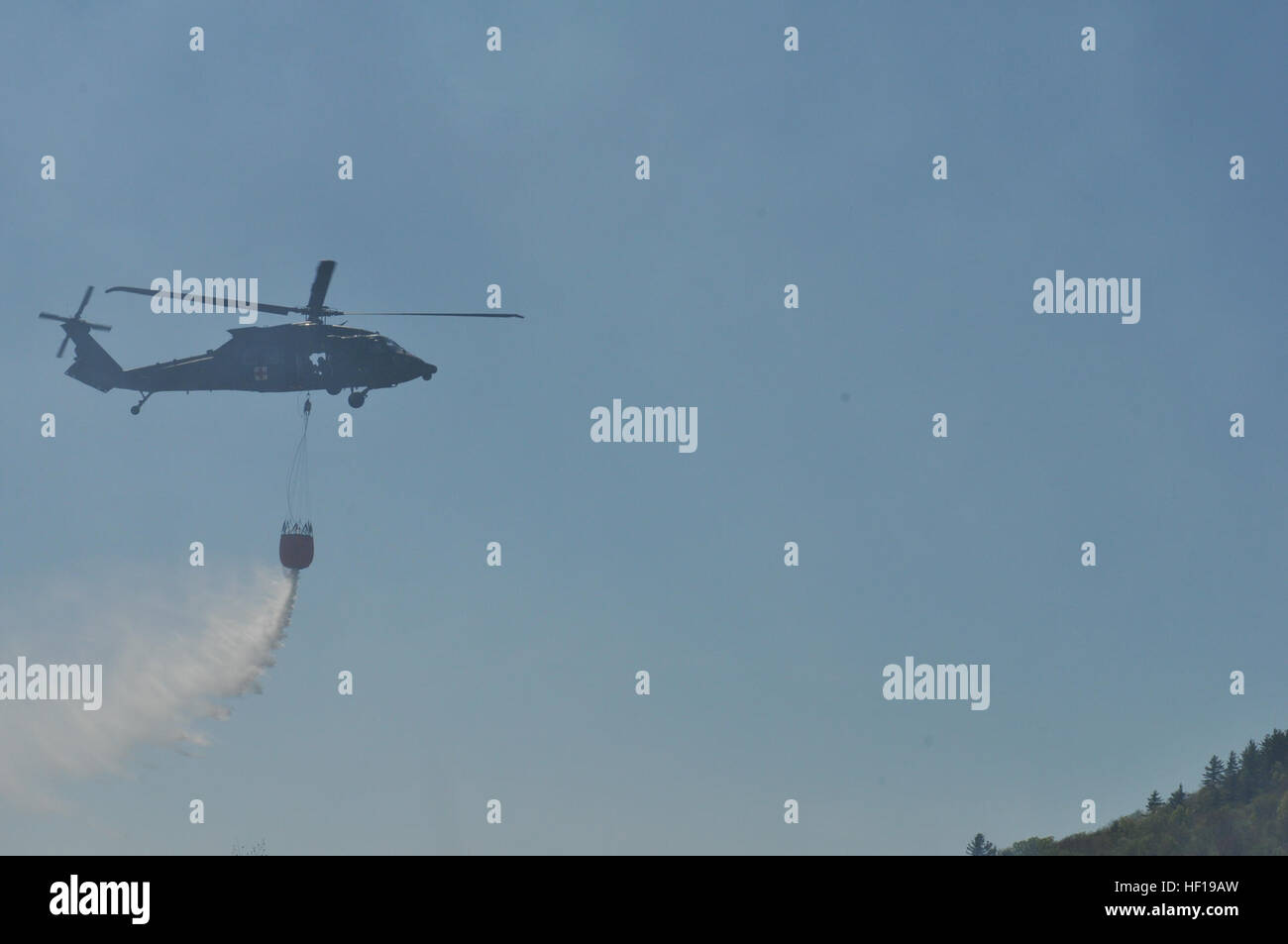 Un HH-60M Black Hawk elicottero azionato dal Vermont esercito nazionale della guardia Charlie Company, 3° Battaglione, 126Reggimento aviazione gocce di acqua su una foresta fuoco al Camp Ethan Allen Sito di formazione di Gerico, Vt., 7 maggio 2013. Il fuoco è stato scatenato durante la formazione gunnery il weekend precedente. (U.S. Foto dell'esercito da 1Lt. Jeffrey Rivard/RILASCIATO) Wildfire supporto aria a Camp Ethan Allen Sito Formazione 130507-Z-WM282-664 Foto Stock