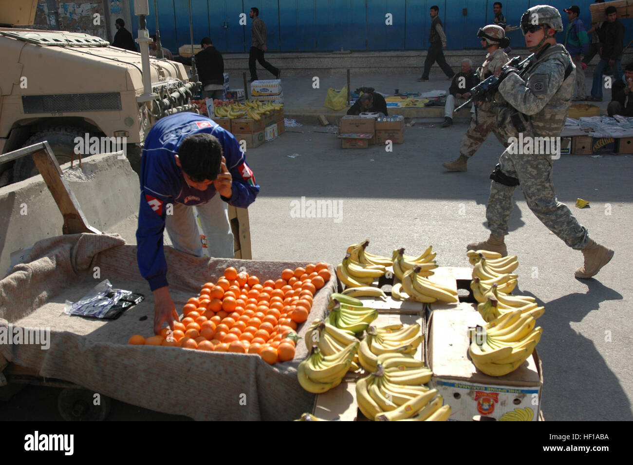 BAGHDAD in Iraq - un venditore ambulante colloqui sul suo telefono cellulare come pattuglia di iracheni e soldati americani passa Febbraio 21, 2007, nel distretto di Rusafa. I soldati facevano parte di una pattuglia di Al Mercato Shuraga guidato da Lt. Gen. Ray odierno, comandante del corpo multinazionale - Iraq, Rusafa capo di polizia Il Mag. Gen. Latiff Mohammed Khalaf e il Mag. Gen. Abdullah Abdul-Karim Abdul-Satar, comandante della brigata di 4°, 1° esercito iracheno divisione. (U.S. Esercito Foto di Sgt. Curt Cashour, MNC-I Affari pubblici) condizioni di sicurezza DVIDS37045 Foto Stock