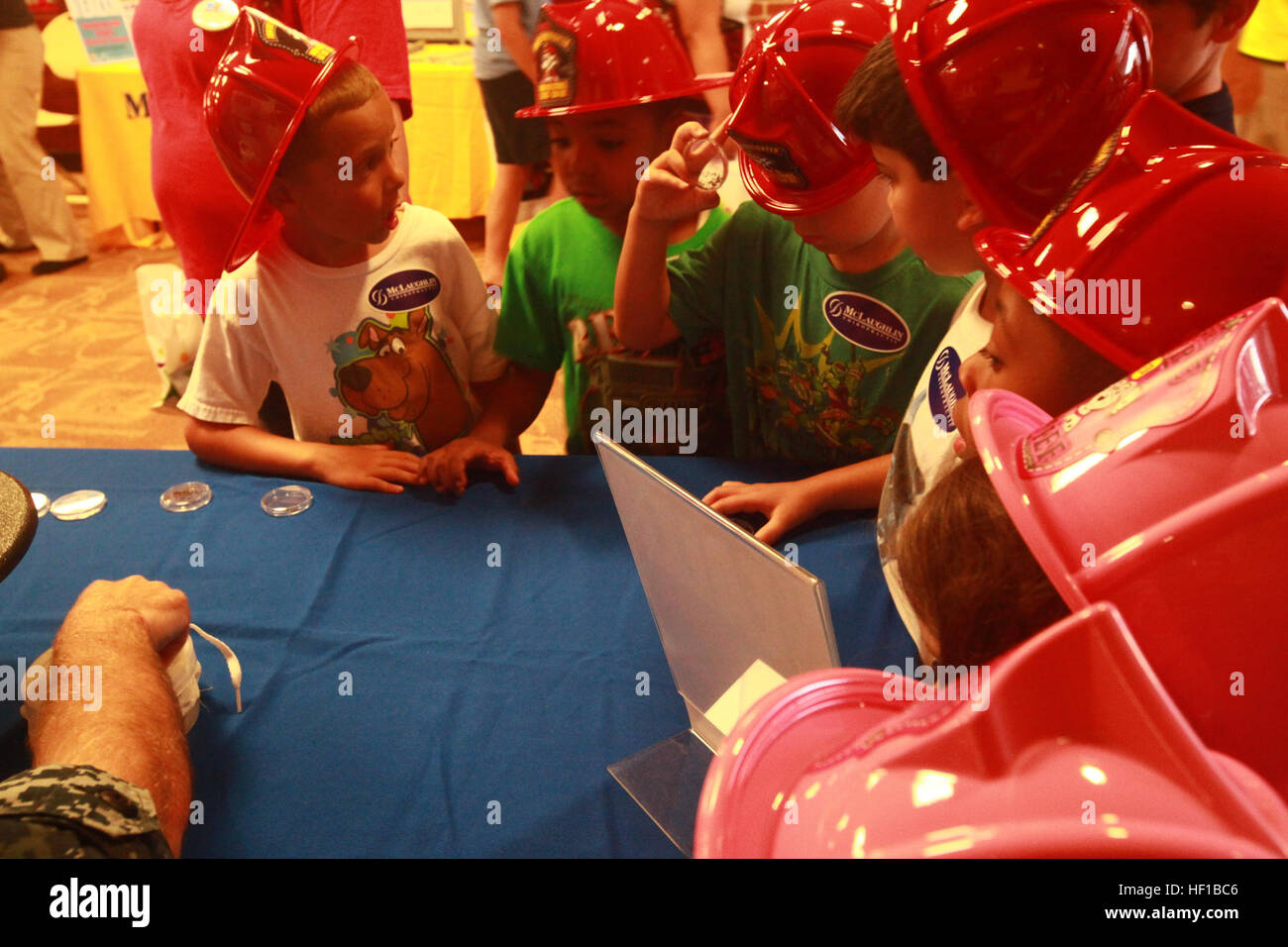 I bambini si radunano attorno a uno stand durante la fiera per visualizzare morti zanzare e imparare a proteggersi dalle punture di bug. I bambini imparano circa la salute, fitness, sicurezza 130621-M-DB277-058 Foto Stock