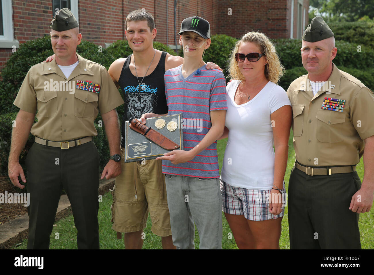 Lt. Col. William Stophel, il comandante per combattere il battaglione della logistica 2, 2° Marine Logistics Group, UFC Fighter Stephen Thompson, Austin Saxton, Christina Saxton e Capt. Lee Stuckey, il comandante della società per il trasporto e supporto Azienda, combattere il battaglione della logistica 2, 2° Marine Logistics Group, posano per una foto dopo Austin è stato premiato con una targa per essere un vero guerriero di Camp Lejeune, N.C., Agosto 02, 2013. Austin è stato diagnosticato con il pancreas e cancro del fegato, ma non ha mai dato di combattere. (U.S. Marine Corps foto di Cpl. Devin Nichols) di cancro alla società Commander 1308 Foto Stock