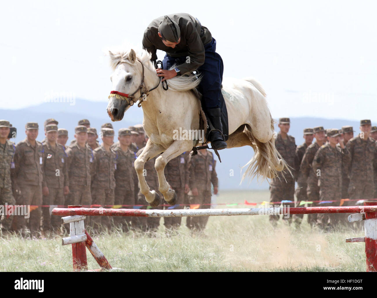 Un membro della Mongolia le forze armate 234 unità di cavalleria, salta il suo cavallo durante la cerimonia di apertura dell'esercizio Khaan Quest in cinque colline Area Formazione, Mongolia, 3 Agosto, 2013. Ricerca Khaan è una multinazionale annuale esercizio sponsorizzato da Stati Uniti e Mongolia, ed è destinato a rafforzare le capacità degli Stati Uniti, mongola e altre nazioni' forze internazionali in operazioni a sostegno della pace.(STATI UNITI Marine Corps Foto di Sgt John M. Ewald/RILASCIATO) Khaan ricerca 2013 - Cerimonia di apertura 130803-M-DR618-137 Foto Stock