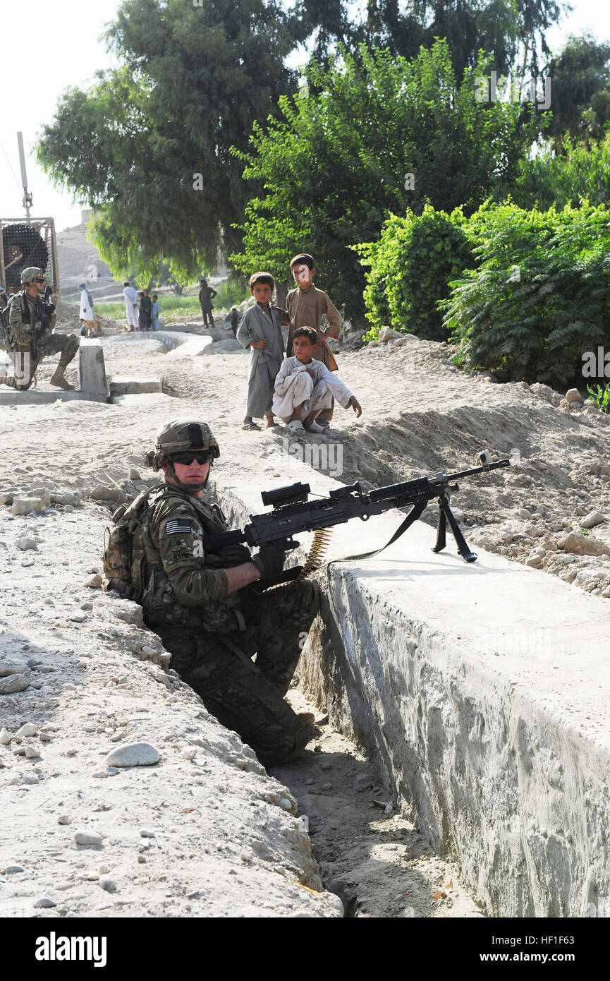 Spc. Casey Salvia, di Keenesburg, Colo., una scout di cavalleria, quarto squadrone, 9° reggimento di cavalleria, 2° Brigata Team di combattimento, 1° Divisione di cavalleria, tira la sicurezza locale mentre i bambini guardano su durante un contatore fuoco indiretto patrol vicino villaggio Lalmah, Chapahar distretto, provincia di Nangarhar, Afghanistan, Sett. 1, 2013. Lavorando a sostegno di una task-force patriota, lo squadrone raccolte informazioni che consentano di International Security Assistance le forze per limitare il potenziale di fuoco indiretto siti sparsi in avanti Base Operationg Fenty. (U.S. Esercito nazionale Guard foto da 1Lt. Il Ciad Carlson, 129Mobile degli affari pubblici Det Foto Stock