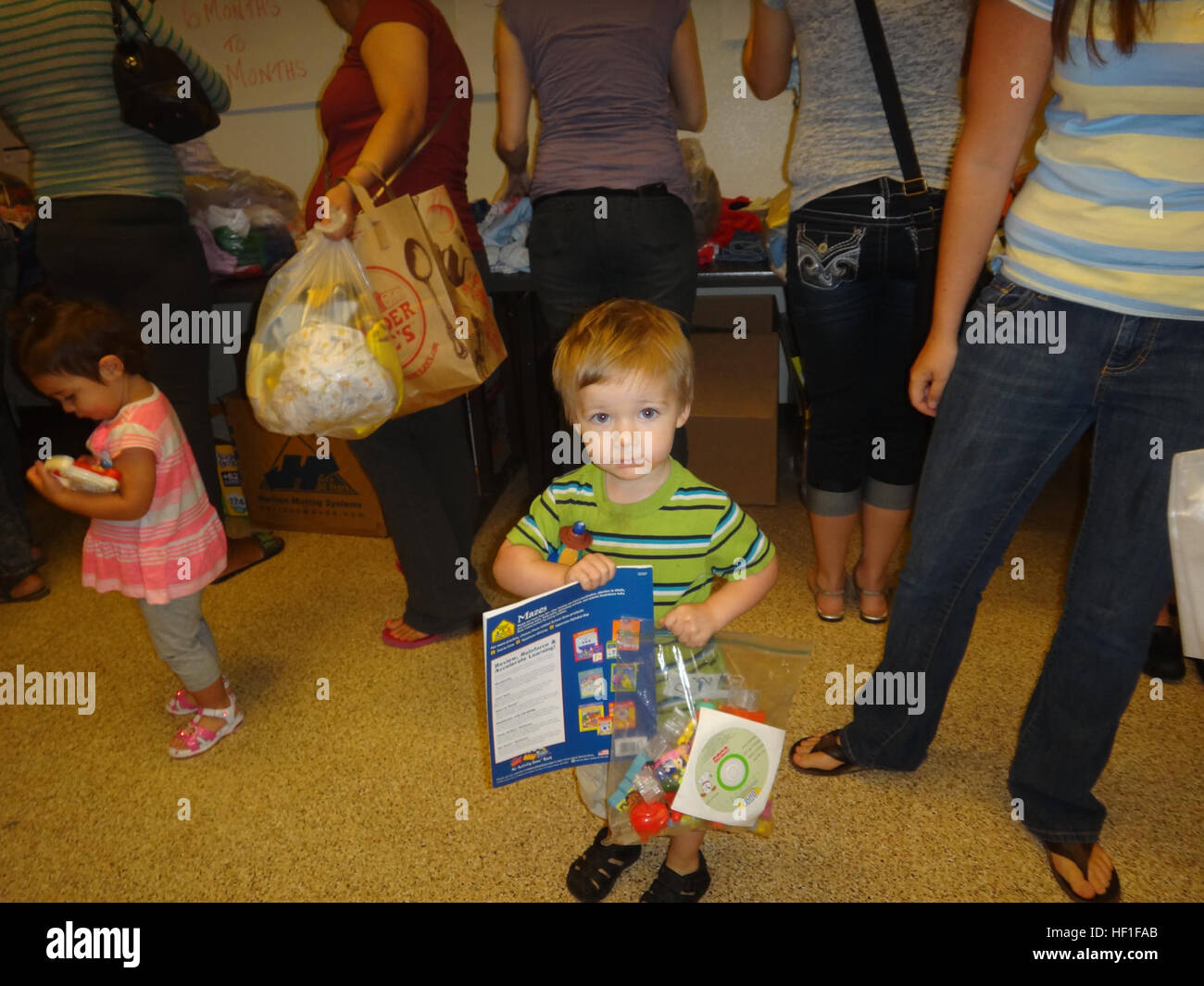 Un bambino mostra fuori i suoi nuovi giocattoli a due volte come bella donazione rally al Marine Corps Air Station Yuma, Ariz., community center, Sett. 7. L'evento ha permesso alle famiglie di donare e ricevere una varietà di bambini vestiti, giocattoli e ingranaggio gratuitamente. (Foto fornite da Erica Ruiz) Due volte bello 130907-M-TH017-009 Foto Stock