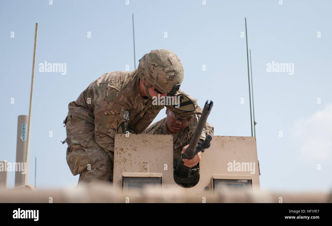 Stati Uniti Army Spc. Ryan Wright, sinistra, un impianti elettrici aggiustatore e SPC. Adrian Feliz, un piccoli bracci repairman, entrambi assegnati alla truppa di Delta, quarto squadrone, 9° reggimento di cavalleria, 2° Brigata corazzate contro la squadra, 1° Divisione di cavalleria, fissare un'arma alla sommità di un blindato carrello a inoltrare una base operativa Fenty, nella provincia di Nangarhar, Afghanistan, Sett. 11, 2013. Delta della truppa di missione a Fenty era il mantenimento, il recupero e la riparazione di tutto da generatori portatili per disabili veicoli da strada di esplosivi. (U.S. Esercito nazionale Guard foto di Sgt. Margaret Taylor/RILASCIATO) cavalleria me Foto Stock