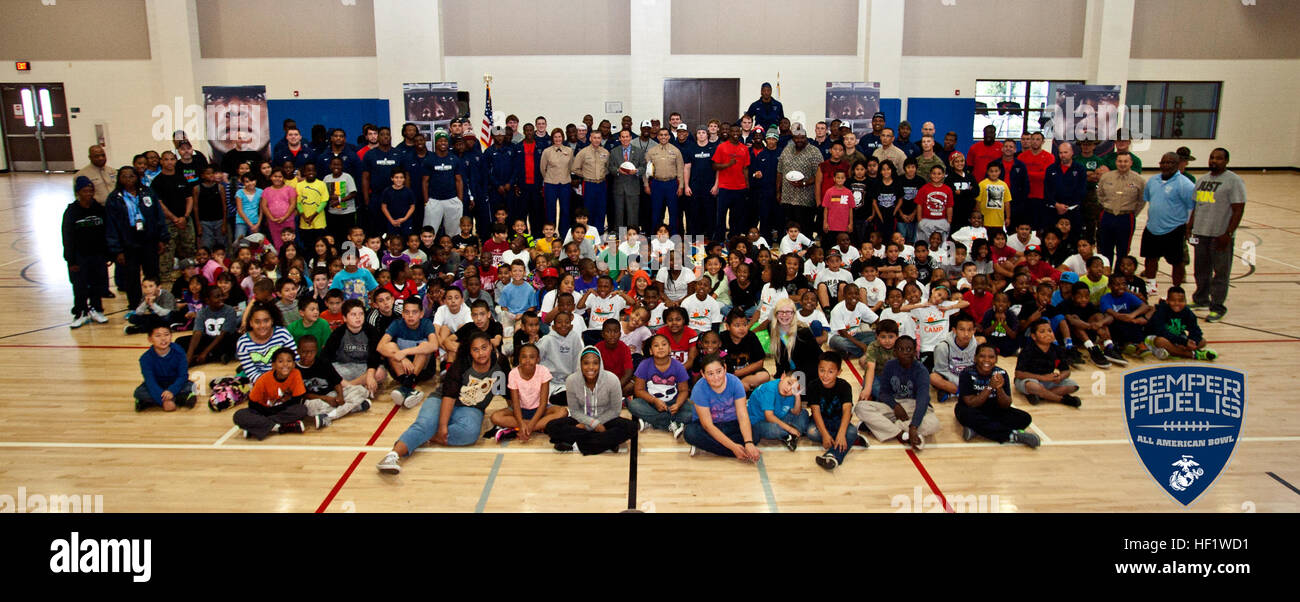 Bambini da vicino a Carson raccogliere con 2014 semper fi giocatori, USMC i deputati e i responsabili politici locali per una foto di gruppo a la Carson Parks & Rec Center di Carson, California. I bambini hanno avuto quindi la possibilità di insegnare la Semper Fi atleti come eseguire in varie attività fisiche e giochi. Semper Fidelis ciotola All-American 140103-M-ZZ999-002 Foto Stock