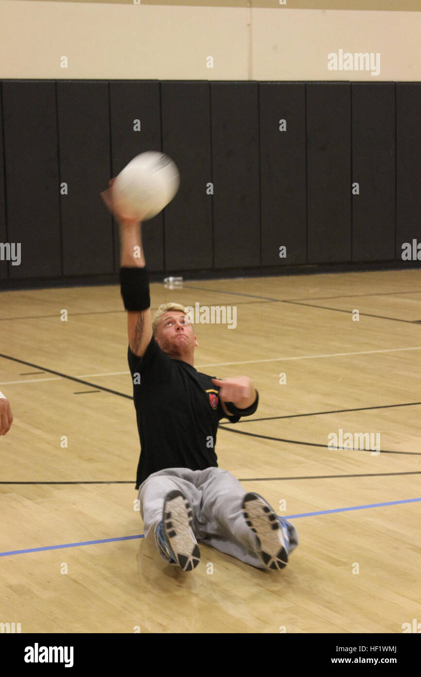 Lancia Cpl. Tim Bergenstock da WWBn-West serve la palla in un scrimmage corrispondere durante il guerriero ferito reggimento seduta Pallavolo Camp presso l'Università della Florida centrale in Orlando. Marines e veterani marino che partecipano al camp si migliorano le loro competenze nelle aree di colpire, passando e servendo la sfera, nonché tecniche difensive. Il guerriero atleta programma di ricondizionamento (guerra-P) fornisce attività e opportunità di feriti, malati o feriti Marines di treno come gli atleti, mentre aumentando la loro forza in modo che possa continuare con il servizio militare o di sviluppare un sano Foto Stock