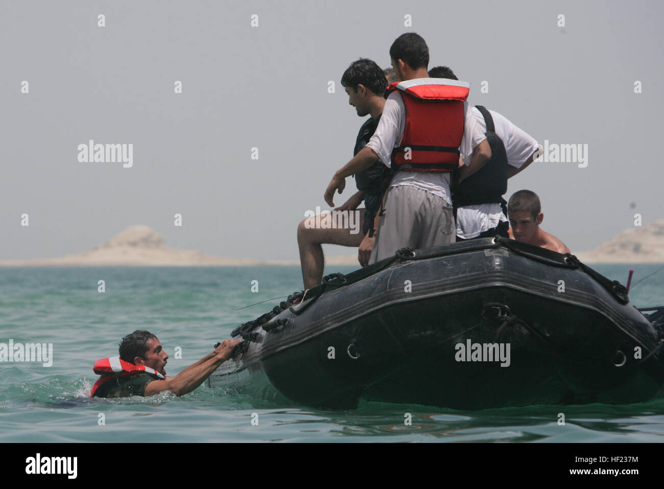 Un poliziotto iracheno nuota verso una pattuglia di Zodiac zattera durante un salvataggio nuoto e classe di condizionamento nel lago Quadsiyah a Haditha, Iraq, Luglio 9, 2008. Poliziotti iracheni da intorno al Anbar stanno frequentando un tecniche di canottaggio e acqua corso di sopravvivenza allo scopo di effettuare l'acqua le operazioni di carico e di aumentare il livello di protezione in tutta Al Anbar i canali navigabili. (U.S. Marine Corps foto di Cpl. Seth Maggard/RILASCIATO) un poliziotto iracheno nuota verso una pattuglia di Zodiac zattera durante un salvataggio nuoto e classe di condizionamento nel lago Quadsiyah a Haditha, Iraq, Luglio 9, 2008 080709-M-QJ743-002 Foto Stock