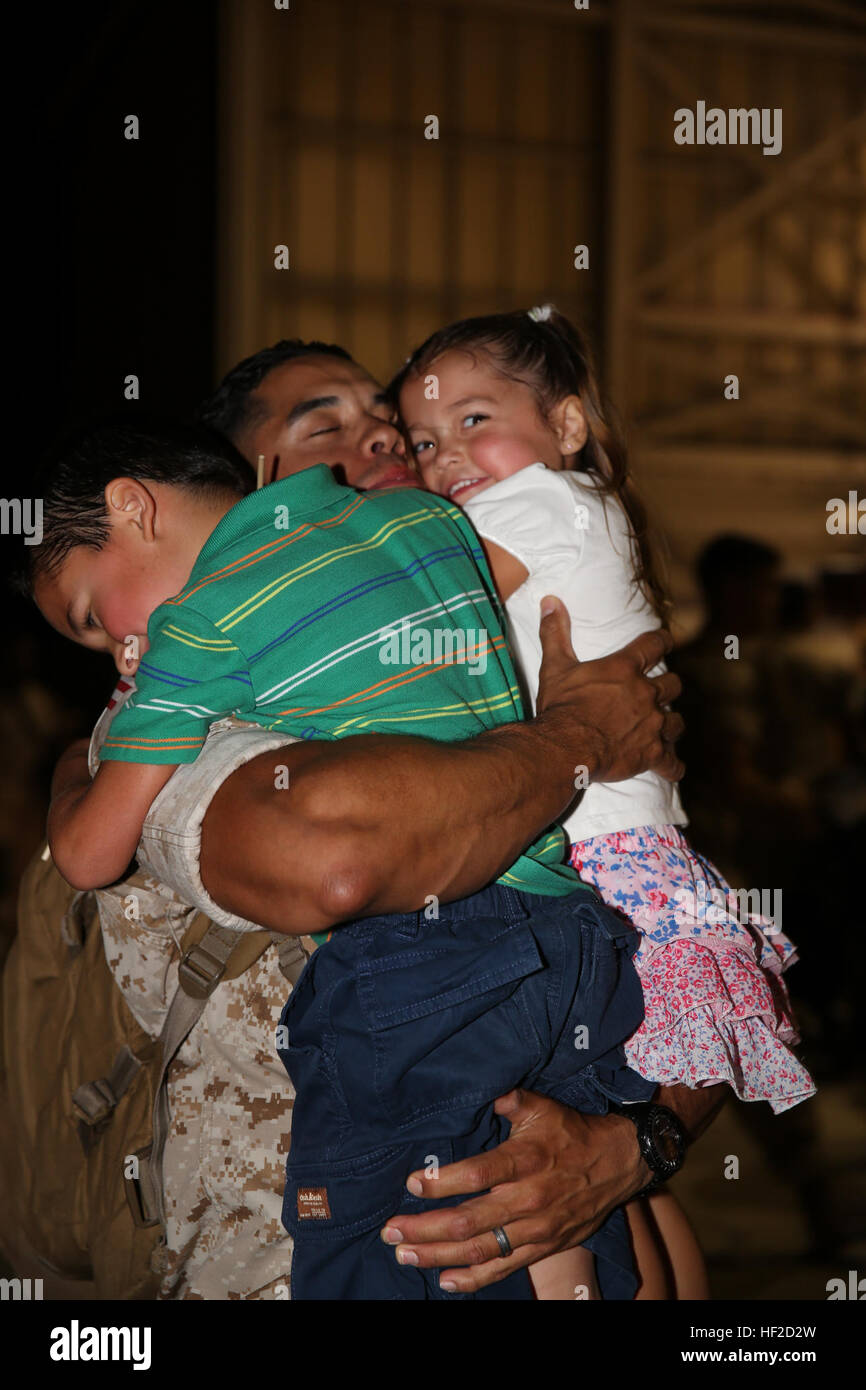 Chief Warrant Officer Alex Cruz sorrisi come egli abbraccia i suoi figli per la prima volta in sette mesi. I marines restituito al Marine Corps Air Station Cherry Point N.C., e il Agosto 8, 2014, dopo sette mesi di distribuzione per il Qatar. Cruz è un segnali intelligence electronic warfare officer con lo squadrone. VMAQ-3 completa distribuzione del Qatar, ritorna al Cherry Point 140808-M-SR938-043 Foto Stock