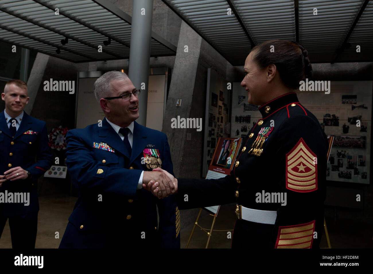 Il Sergente Maggiore della caserma marini Washington, Sgt. Il Mag. Angela Maness, destra saluta uno del tramonto Parade ospiti d'onore, Master Chief Petty Officer della Coast Guard, Master Chief Petty Officer Steven W. Cantrell, durante la sfilata ricevimento in donne in servizio militare per l'America Memorial in Arlington, Virginia, Agosto 12, 2014. La reception era in onore del mare-rami di base del servizio. (U.S. Marine Corps photo by Lance Cpl Giacobbe R. Bozic/RILASCIATO) Tramonto Parade 140812-M-GR671-022 Foto Stock