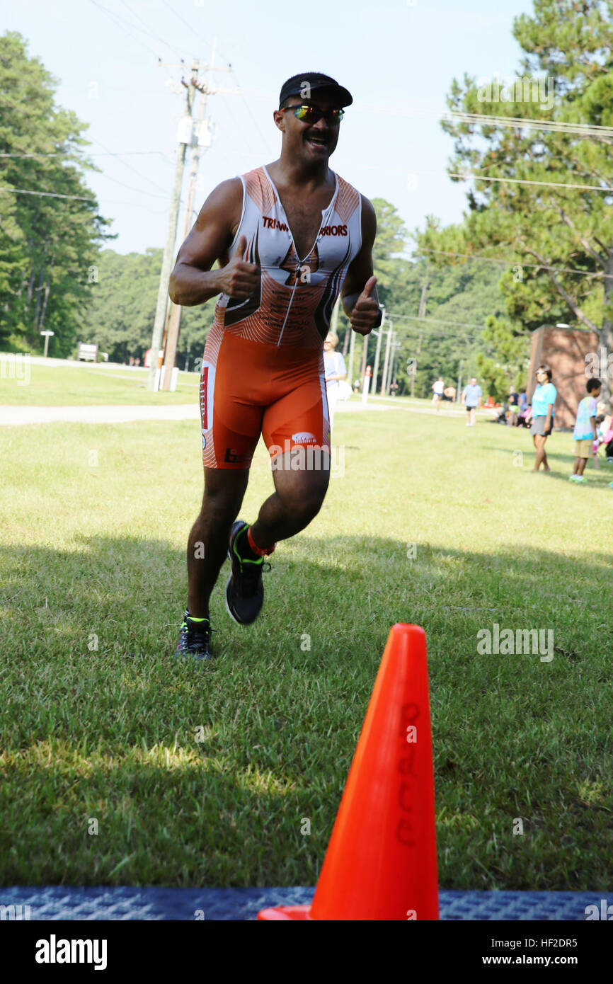 Contrassegnare Lockler dà un pollice in su prima di attraversare la linea del traguardo di Marine Corps servizi comunitari' Triathlon Sprint/relè a Marine Corps Air Station Cherry Point, N.C., Agosto 16, 2014. Lockler finito prima nel 40-44 gruppo di età. Lockler è un avvocato locale e nativo di Lumberton, N.C. I concorrenti nuoto, ciclismo, corsa al traguardo 140816-M-BN069-033 Foto Stock