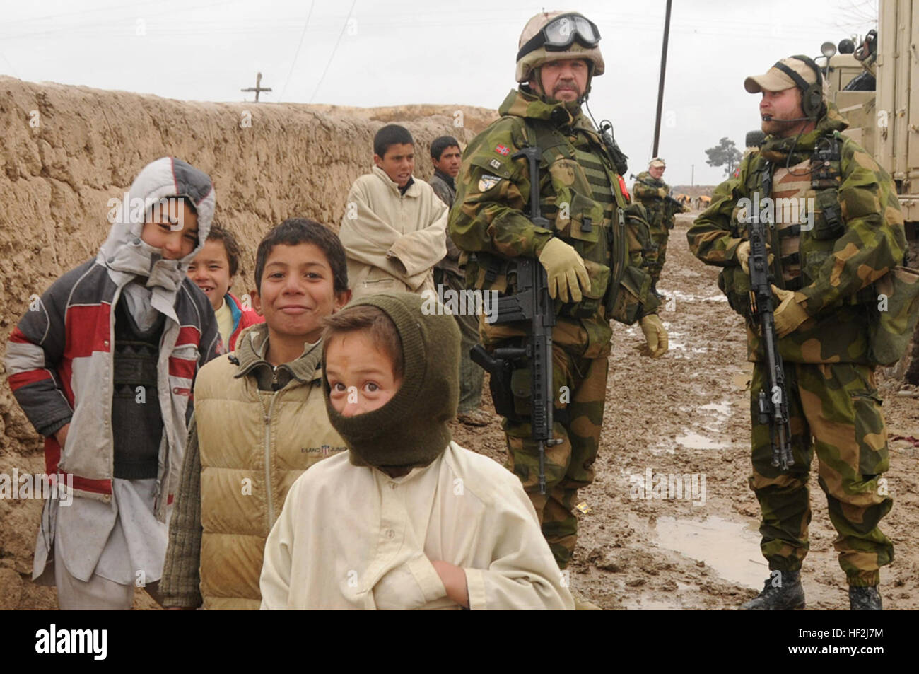 I bambini a stare di fronte della Forza internazionale di assistenza alla sicurezza dei soldati con il norvegese elemento di supporto e il norvegese della Guida operativa e Liaison Team a Mazar-e-Sharif, Feb. 4. I norvegesi stanno aiutando ISAF per aiutare il governo afghano in estensione e di esercitare la sua autorità e la sua influenza in tutto il paese e di creare le condizioni per la stabilizzazione e la ricostruzione. Norvegese soldati ISAF Foto Stock