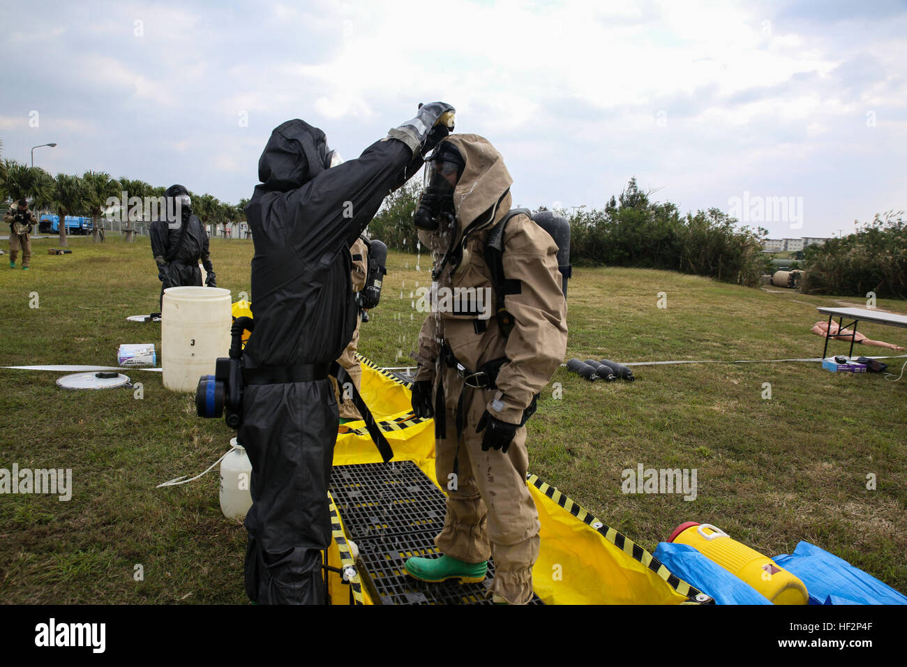 Chimico, biologico, radiologico e nucleare e gli specialisti della difesa decontaminare le squadre che è entrato simulato e area contaminata durante una valutazione/conseguenze esercizio di gestione 5 Dicembre a Camp Hansen. Il centro di decontaminazione ha tre bacini: uno per applicare e risciacquare la decontaminazione agent, uno per assicurare l'assenza di contaminanti sono stati lasciati sulla tuta e il bacino finale è di monitorare Marines come essi prendere fuori i loro abiti per garantire nulla di nocivo ottiene sulla loro pelle. I marines sono con il trentunesimo Marine Expeditionary Unit. (U.S. Marine Corps photo by Lance Cpl. Ryan C. Rete/RILASCIATO) CBRN Foto Stock