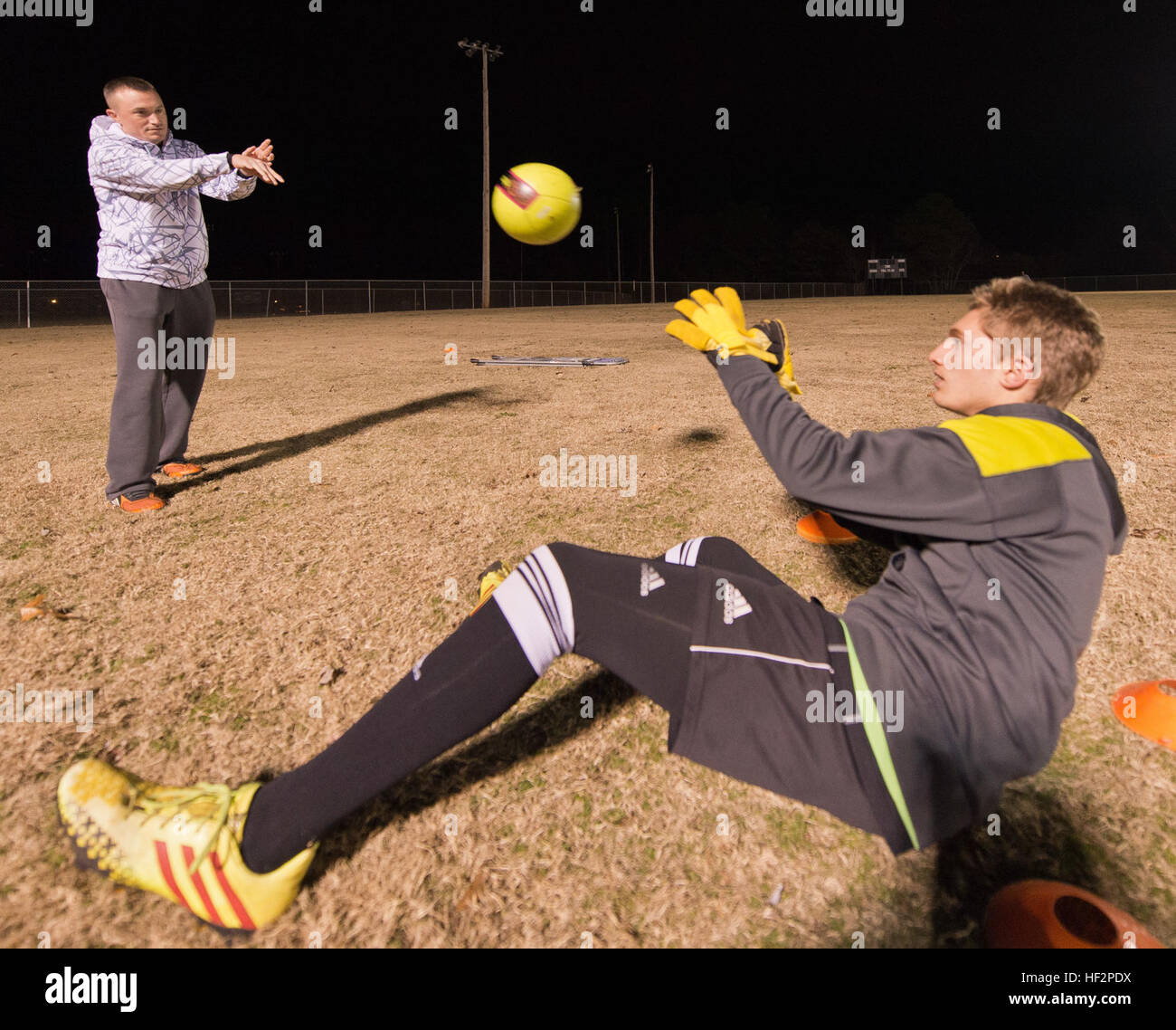 Stati Uniti Air Force Master Sgt. Jason Butts, sinistra, una messa a terra di sicurezza degli esplosivi artigiano con la 116aria ala di controllo, Georgia Air National Guard, lanci di un pallone da calcio per uno dei giocatori ha pullman durante una pratica svoltasi a Warner Robins, Ga., Dicembre 9, 2014. Butts sormontato migliaia di compagni di pullman da 12 membri a prendere l'onore come la regione 3 ragazzi ricreative allenatore di calcio dell'anno per un team da lui pullman in Warner Robins, Ga. Ha anche vinto il primo posto come allenatore dell'anno per lo stato della Georgia e la sua squadra ha vinto tre consecutivi campionati di stato. Butts ha servito come un coa di calcio Foto Stock