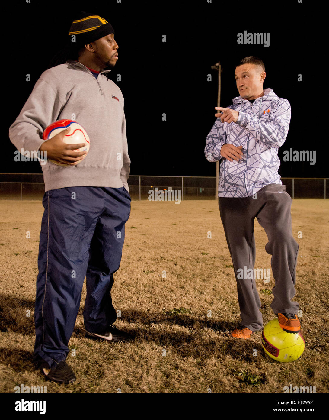 Stati Uniti Air Force Master Sgt. Jason Butts, destra, una messa a terra di sicurezza degli esplosivi artigiano con la 116aria ala di controllo, Georgia Air National Guard, parla di co-allenatore, Chris Harris, sulla strategia di gioco durante una pratica svoltasi a Warner Robins, Ga., Dicembre 9, 2014. Butts sormontato migliaia di compagni di pullman da 12 membri a prendere l'onore come la regione 3 ragazzi ricreative allenatore di calcio dell'anno per un team da lui pullman in Warner Robins, Georgia. Ha anche vinto il primo posto come allenatore dell'anno per lo stato della Georgia e la sua squadra ha vinto tre consecutivi campionati di stato. Butts ha servito come un socce Foto Stock