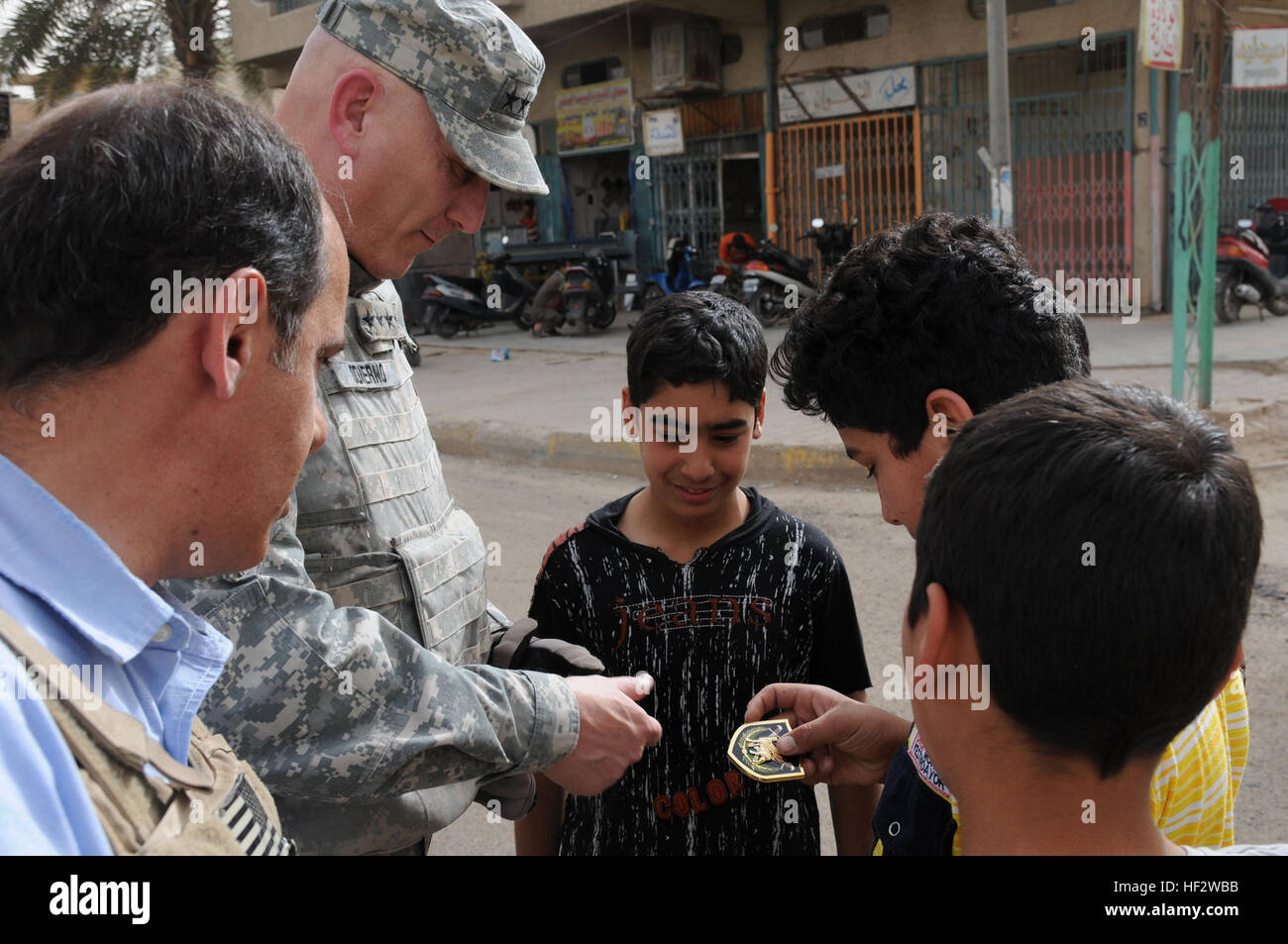 Gen. Ray odierno, comandante generale Force-Iraq multinazionali, dà alcuni ragazzi locali MNF-io le monete durante la sua passeggiata attraverso Adhamiyah Mercato del Pesce apr. 22. La passeggiata era parte di una valutazione della sicurezza e visita al 1° Brigata Team di combattimento, 1° Divisione di cavalleria, giunto alla stazione di sicurezza War Eagle. (Foto di US Army Spc. Kimberly Millett, MNF-I Affari pubblici) Force-Iraq multinazionali Comandante generale visite DVIDS Adhamiyah167069 Foto Stock