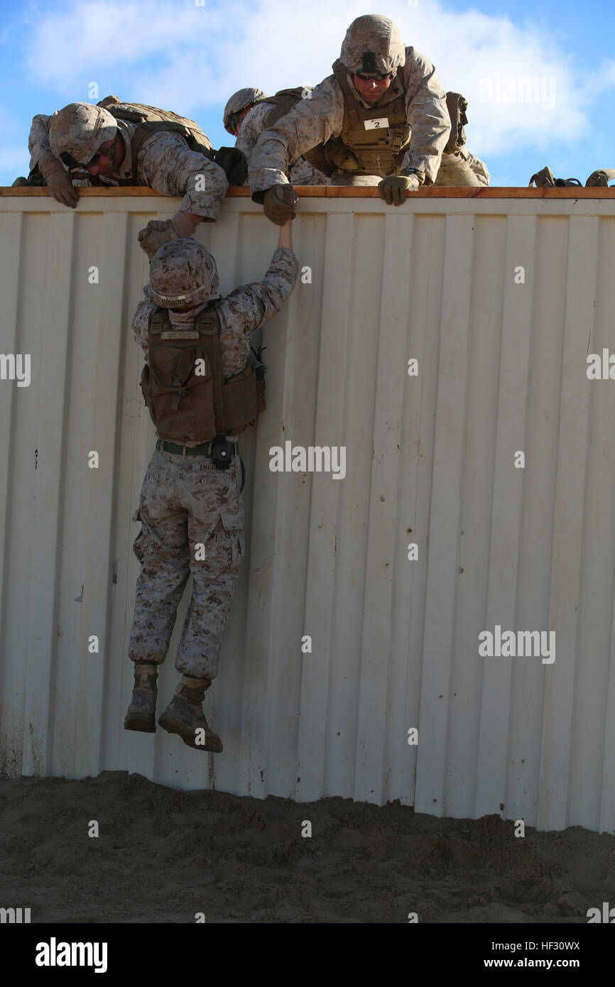 Marines con sezione Anti-Armor, armi Company, il combattimento a terra integrati elemento Task Force, il comportamento di un incendio-team sollevamento assistito oltre ad otto piedi parete ostacolo durante un test pilota a gamma 107, Marine Corps Air Ground Centro di combattimento ventinove Palms, California, il 2 marzo 2015, in preparazione per il Marine Corps Prova di funzionamento e di attività di valutazione Valutazione. Da ottobre 2014 a luglio 2015, il GCEITF sarà condotta individuale e collettivo di competenze di livello di formazione in designato il combattimento a terra i bracci di specialità professionali al fine di facilitare la basata su standard di valutazione il fisico Foto Stock