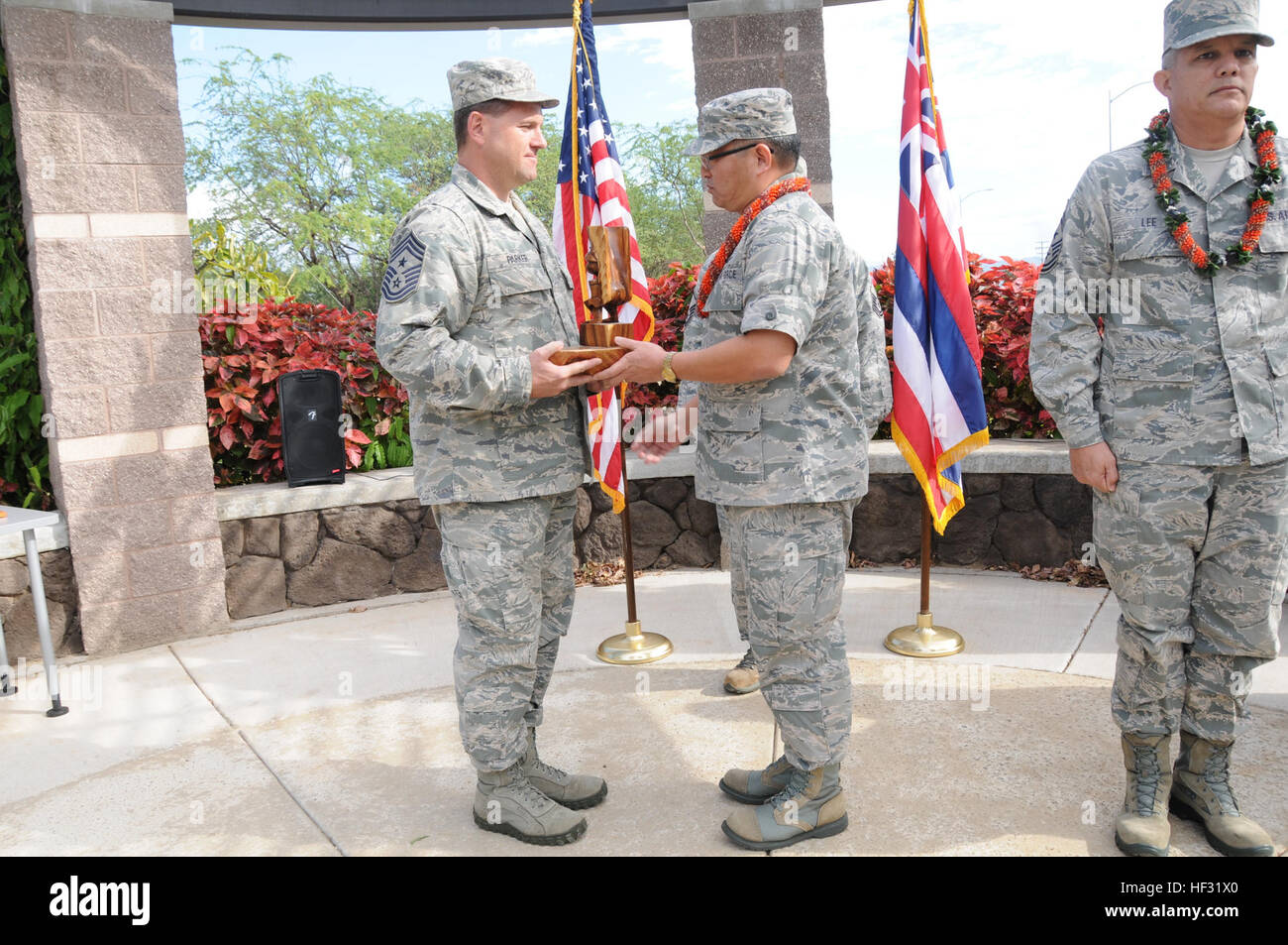 Stati Uniti Air Force Chief Master Sgt. William A. Parker, Hawaii Air National Guard 154Ingegneria Civile Squadron, riceve il "Kuka'ilimoku," il re Kamehameha la guerra di dio, statua da Briga. Gen. Ryan Okahara, comandante delle Hawaii Air National Guard, durante una cerimonia di pinning a base comune Harbor-Hickam perla, il 8 marzo 2015. La base della statua è stato realizzato a mano da pensionati Brig. Gen. Stanley Osserman. (U.S. La Guardia Nazionale foto di Airman 1. Classe Robert Cabuco) cerimonia di pinning per Chief Master Sgt. William A. Parker 150308-Z-UW413-151 Foto Stock
