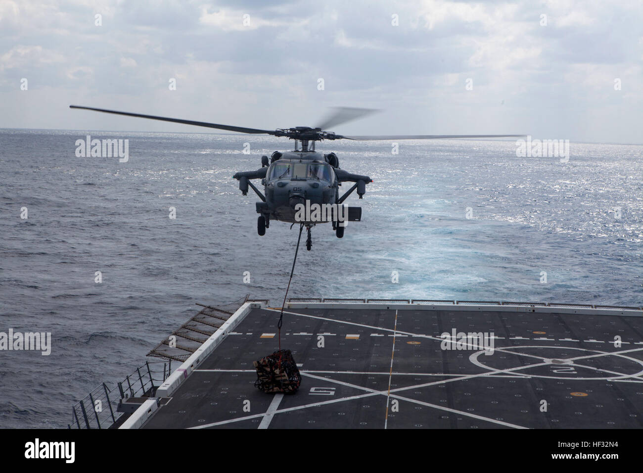 Un U.S. Navy MH-60 Seahawk offre cibo e materiali di consumo per la USS Green Bay (LPD 20) mentre sul mare, il 11 marzo 2015. Il Green Bay sta attualmente conducendo la sua pattuglia di primavera della regione Asia-Pacifico. (U.S. Marine Corps photo by GySgt Ismael Peña/RILASCIATO) il rifornimento in mare 150311-M-CX588-091 Foto Stock