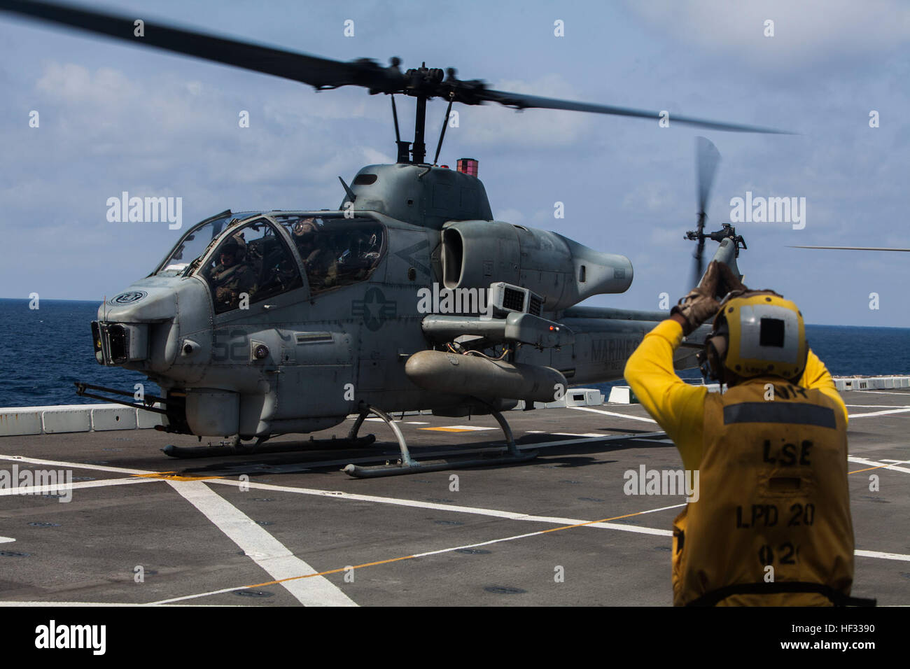 Un U.S. Aviazione Navale di Boatswain Mate segnali a U.S. Marine Corps AH-1 Super Cobra assegnato a mezzo marino Tiltrotor Squadron 262 (rinforzato), 31 Marine Expeditionary Unit (MEU), mentre si prepara a prendere il via dal ponte di volo della USS Green Bay (LPD 20) mentre sul mare, il 11 marzo 2015. Il trentunesimo MEU sta attualmente conducendo la sua pattuglia di primavera della regione Asia-Pacifico. (U.S. Marine Corps photo by GySgt Ismael Peña/RILASCIATO) VMM 262 (Rein) a bordo della USS Green Bay 150314-M-CX588-048 Foto Stock