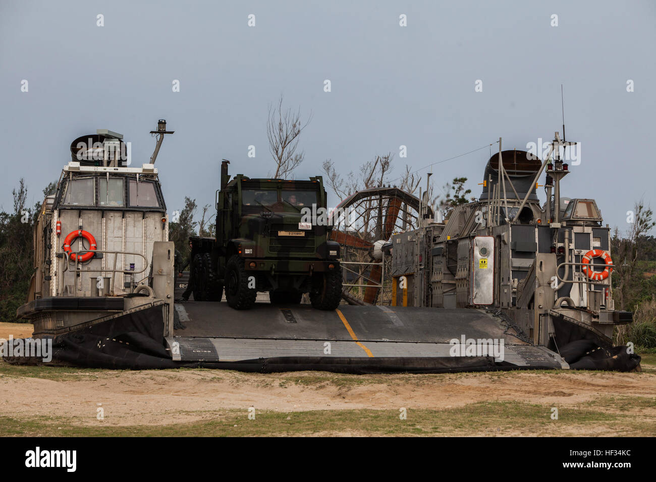 Stati Uniti Marines con il combattimento il battaglione della logistica 31, 31 Marine Expeditionary Unit (MEU), offload un mezzo tattico di sostituzione del veicolo a 7 ton carrello da una landing craft, cuscino d'aria su Kin, Okinawa, in Giappone, 21 marzo 2015. Il trentunesimo MEU sta attualmente conducendo la sua pattuglia di primavera della regione Asia-Pacifico. (U.S. Marine Corps photo by GySgt Ismael Peña/RILASCIATO) Nave a riva offload 150321-M-CX588-112 Foto Stock