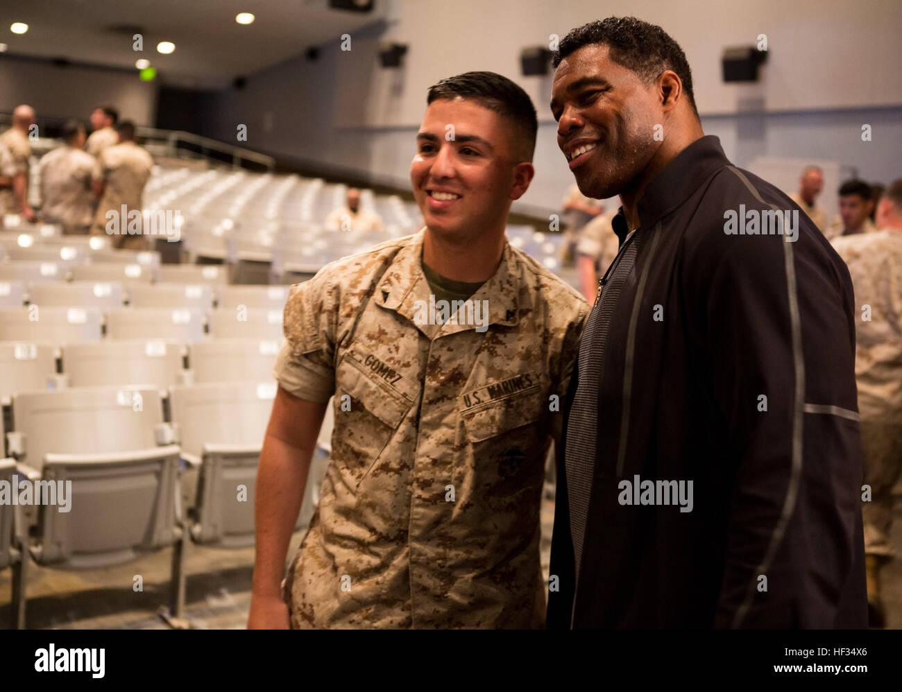Herschel Walker pone con un Marine dopo aver discusso l'importanza di cercare aiuto per la malattia mentale e abuso di sostanze con Marines Marzo 24, 2015, a bordo di Marine Corps base Camp Pendleton, California Walker fornisce ora emozionali e motivazionali di supporto per i membri del servizio, i veterani e le famiglie militari mediante conduzione di impegni presi in pubblico in impianti militari a livello nazionale. Heisman vincitore del trofeo, Herschel Walker parla con Marines 150324-M-JH782-005 Foto Stock