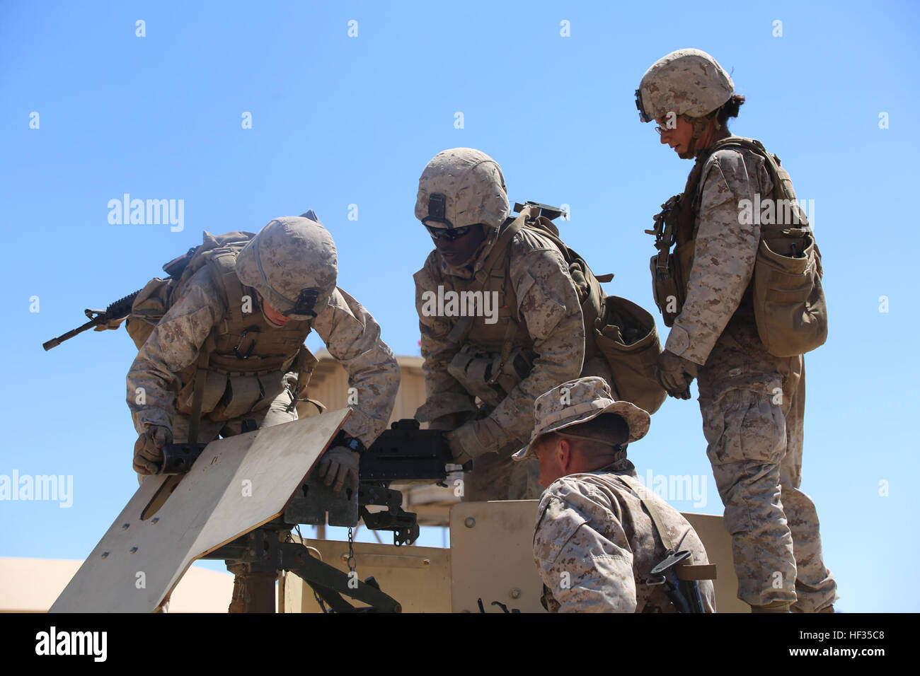 Sergenti Victoria Polonia, sinistra, Tara Copeland, centro e Cpl. Sarah Wentling, destra, tutti i mitraglieri con la mitragliatrice sezione, armi Company, il combattimento a terra integrati elemento Task Force, montare un 0,50 Caliber machine gun sulla cima di un Humvee come Gunnery Sgt. Michael Beagle, società sergente gunnery, armi Co., GCEITF, osserva durante un Marine Corps Prova di funzionamento e di attività di valutazione di valutazione alla gamma 110, Marine Corps Air Ground Centro di combattimento ventinove Palms, California, 28 marzo 2015. Da ottobre 2014 a luglio 2015, il GCEITF sarà condotta individuale e collettiva di competenze di livello tr Foto Stock
