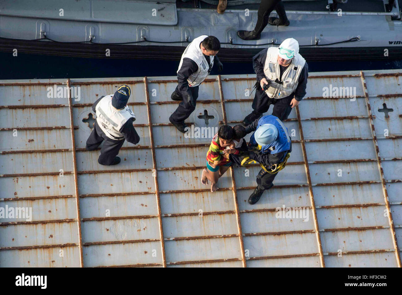 Stati Uniti Marines e marinai con il quindicesimo Marine Expeditionary Unit e la Essex anfibio gruppo pronto aiuto angosciate dei marittimi a bordo del USS Rushmore (LSD 47) in Stretto di Makassar, 10 giugno 2015. Rushmore resi assistenza al distressed marittimi nelle acque tra le isole indonesiane di Kalimantan e Sulawesi. Una volta a bordo, gli sfollati sono stati forniti cibo e cure mediche da marines e marinai del XV Marine Expeditionary Unit ed Essex anfibio gruppo pronto. (U.S. Marine Corps foto di Sgt. Emmanuel Ramos/RILASCIATO) 65 indonesiani salvato dalla tragedia di U.S. Marines, a Vela Foto Stock