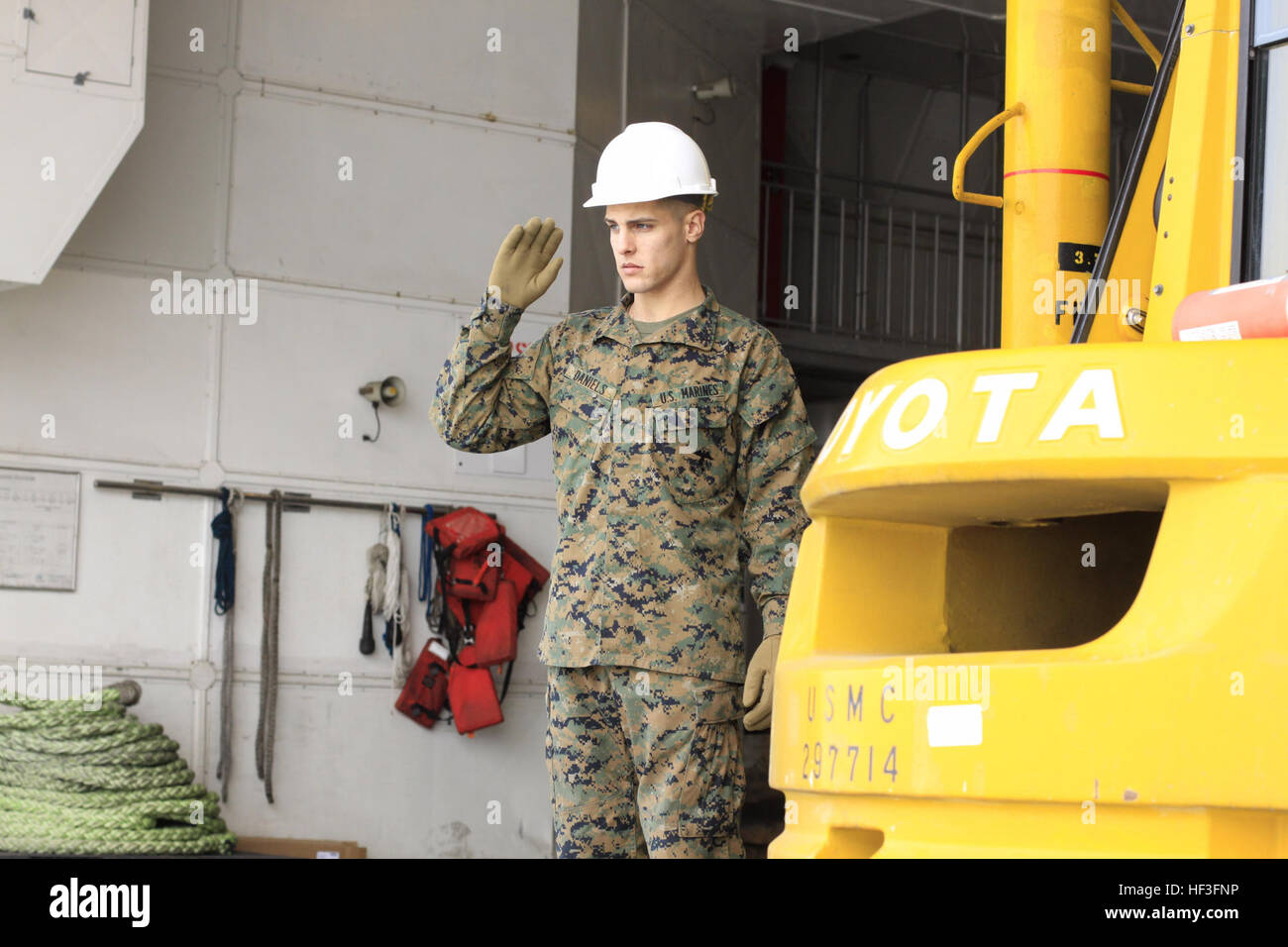 Pfc. Robert Daniels, combattere la società di logistica Logistica 36 embarker, segnali di traffico di carrello elevatore a forche su on e off la elevata velocità nave WestPac Express presso la stazione di porto qui, Marzo 23. L'equipaggio di HSV è arrivato qui, 22 Marzo da Pohang, Corea del Sud con più di 230 tonnellate di pallet di bottiglie di acqua che è programmato per essere trasportati tramite KC-130J aeromobile da qui a Sendai, Giappone, a sostegno del funzionamento Tomodachi. Marines, marinai operazione di sostegno Tomodachi da aria, terra, mare 110322-M-KW153-166 Foto Stock