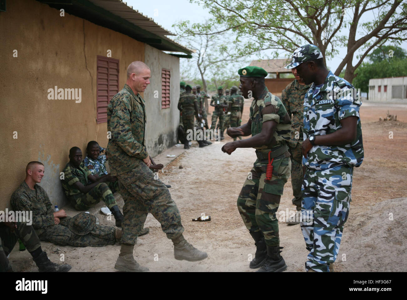 Lancia Cpl. Caleb Dehoog imita senegalesi Commando Marino Mohamed Thaim come egli cerca di imparare un nuovo spettacolo di danza si muovono durante un guerriero della notte qui di recente. Cibo, musica e un intreccio di culture impostare la barra per la sera della morale come Stati Uniti Marines, Commandos senegalesi e Nigerian Navy Special Boat Service gli operatori abbiamo consumato un pasto caldo come una chiusura a Toubakouta capitolo dell'Africa Partnership Station 2011 di strutture militari di exchange. (U.S. Marine Corps photo by Lance Cpl. Timothy L. Solano) guerriero della notte si conclude la fase uno di noi senegalesi 110428 exchange-M-DF801-038 Foto Stock