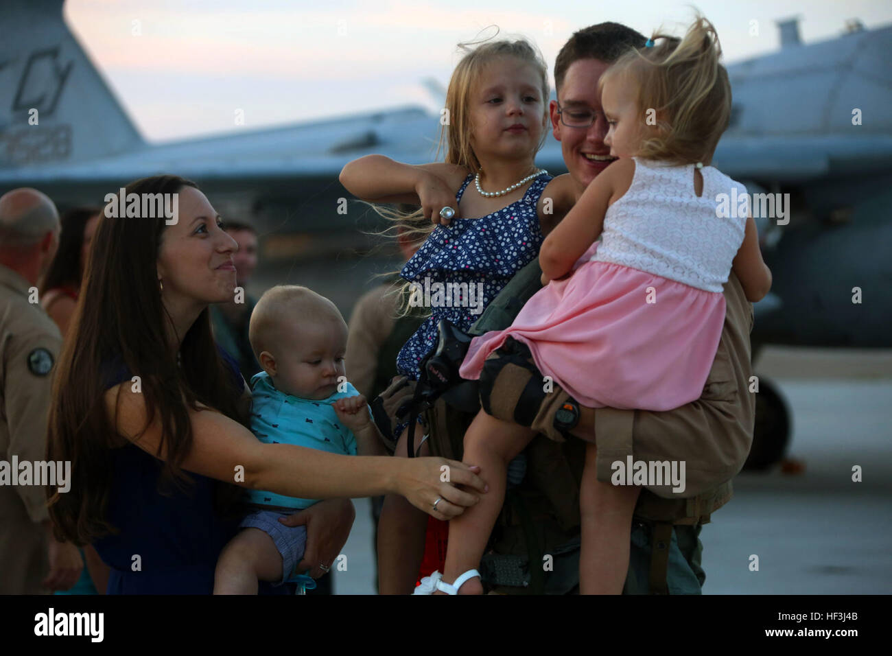 Michaela Winings, sinistra e i suoi tre bambini benvenuti home Capt. Nathan Winings al suo ritorno da una distribuzione con gli Stati Uniti Pacifico Comando al Marine Corps Air Station Cherry Point, Carolina del Nord, e il Agosto 9, 2015. Marine Tactical Electronic Warfare Squadron 2 restituito da una distribuzione a sostegno degli Stati Uniti Pacifico Comando. Lo squadrone fornito airborne electronic warfare nella regione Asia Pacifico nel corso di questa distribuzione. Winings è un EA-6B Prowler pilota con lo squadrone. (U.S. Marine Corps foto di Cpl. N.W. Huertas/RILASCIATO) VMAQ-2 home ha accolto a braccia aperte 150809 Foto Stock