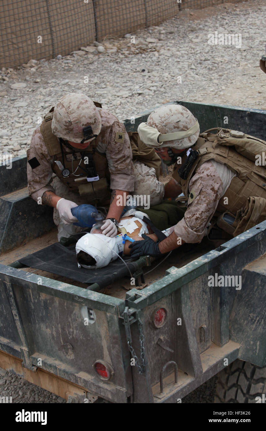 Hospital corpsmen assegnato all India Company, 3° Battaglione, 4° Reggimento Marine, tendono ad un ragazzo ferito a inoltrare una base operativa Golestan nella provincia di Helmand in Afghanistan. Il ragazzo caduto da un'altezza sconosciuta ed era in condizioni critiche. Corpsmen cura per il ragazzo ferito DVIDS220663 Foto Stock