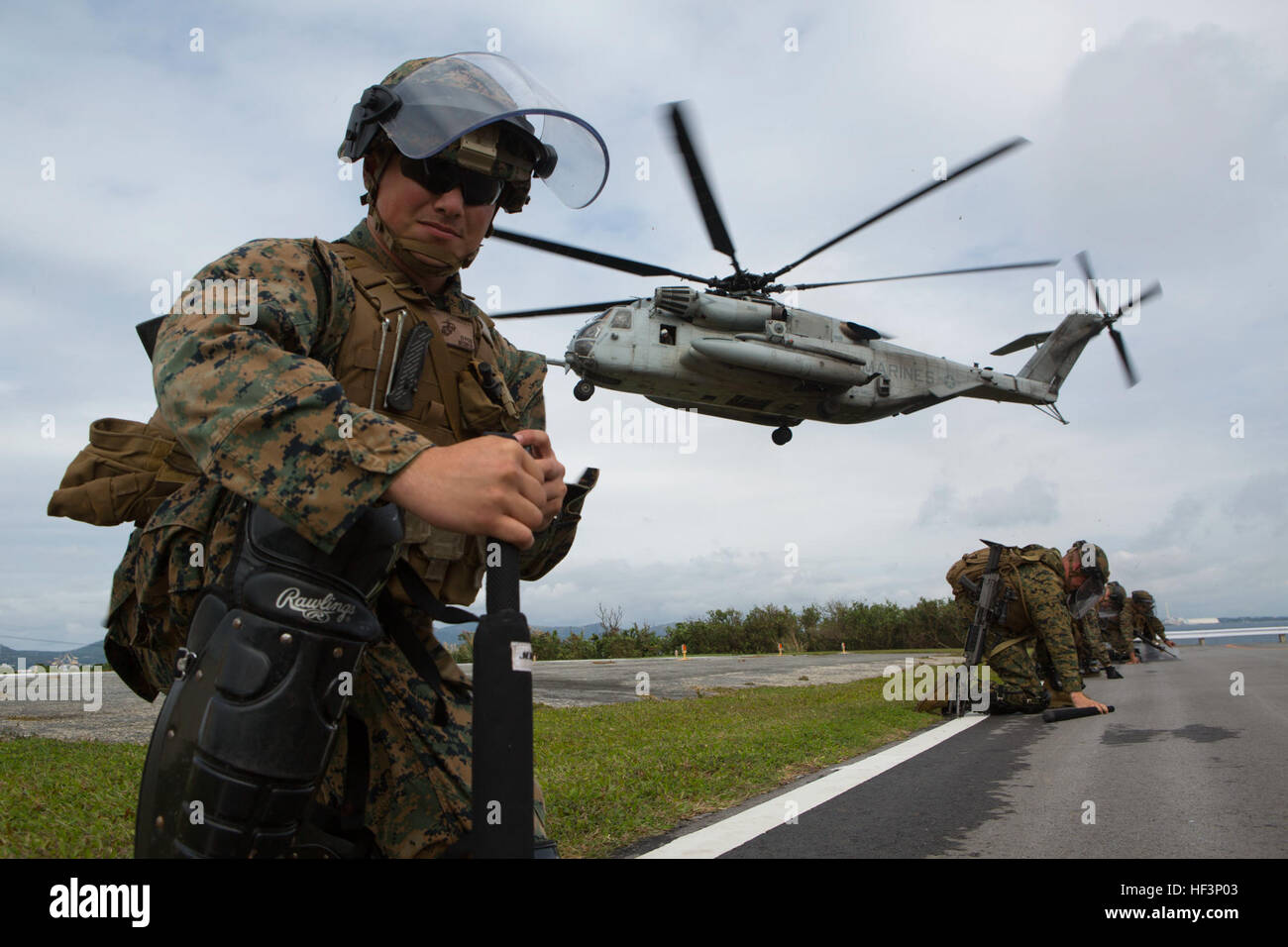 Marine della Golf Battery, Battalion Landing Team, 1st Battalion, 5th Marines, 31st Marine Expeditionary Unit, conducono assistenza umanitaria e addestramento di soccorso in caso di calamità presso Camp Courtney, Okinawa, Giappone, 15 dicembre 2015. I marine simulano la distribuzione di cibo e acqua sotto il lavaggio del rotore da un elicottero CH-53E Super Stallion e gestiscono il controllo della folla come parte di un rapido esercizio di forza di reazione. Foto Stock