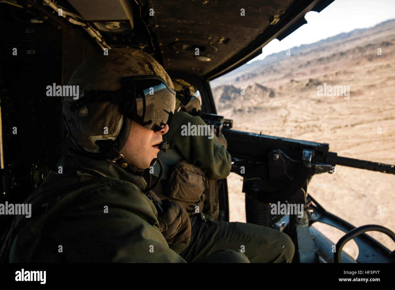 Sgt. Benjamin Hebert, un capo equipaggio con Marine Attacco leggero elicottero Squadron 469 (HMLA-469), in base al di fuori del Marine Corps Air Station Camp Pendleton, California, osserva e verifica hit come Sgt. Daniel O'Niel, un osservatore dell'antenna, gli incendi un GAU-21 mitragliatrice da un UH-1Y "veleno", durante l'esercizio "Scorpion Fire", presso il cioccolato Mountain Aerial Gunnery gamma, Venerdì, Febbraio 5, 2016. HMLA-469, in volo e nella lotta 160205-M-VR252-590 Foto Stock