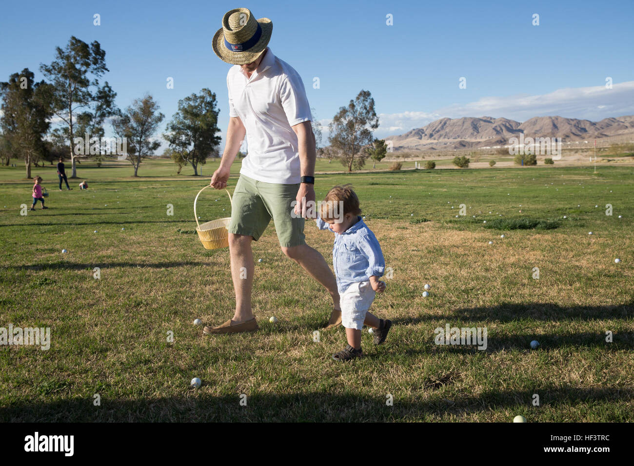 Gunnery Sgt. Giacobbe Mahaffey, logistica chief, Sede Società, 7° Reggimento Marine, aiuta il suo 1-anno-vecchio figlio, Lincoln, raccogliere uova mentre partecipano in un uovo caccia durante il 7° Reggimento Marine Eggstravaganza di primavera tenutosi presso il Desert Winds Campo da Golf, 11 marzo 2016. (Gazzetta Marine Corps foto di Medina Ayala-Lo/RILASCIATO) 'Magnificent settimo' famiglie partecipare nella primavera Eggstravaganza 160311-M-RO214-055 Foto Stock
