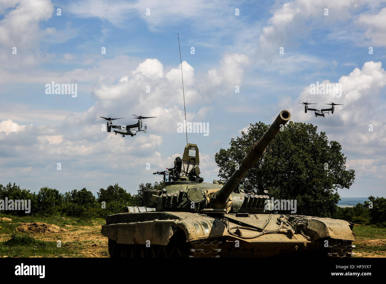 Stati Uniti Marine Corps MV-22 Asprì sorvolare un bulgaro T-72 serbatoio durante il platino Lion 16-3 a bordo di Novo Selo Area Formazione, Bulgaria, 11 maggio 2016. Centinaia di soldati provenienti da cinque paesi della NATO si sono riuniti a formare con attività meccanizzata e dimostrare la capacità di lavorare senza problemi come una forza. (U.S. Marine Corps foto di Cpl. Immanuel M. Johnson/RILASCIATO) U.S. Marines treno al fianco di nazioni partner per rafforzare l'integrazione (immagine 1 di 12) 160511-M-PJ201-879 Foto Stock