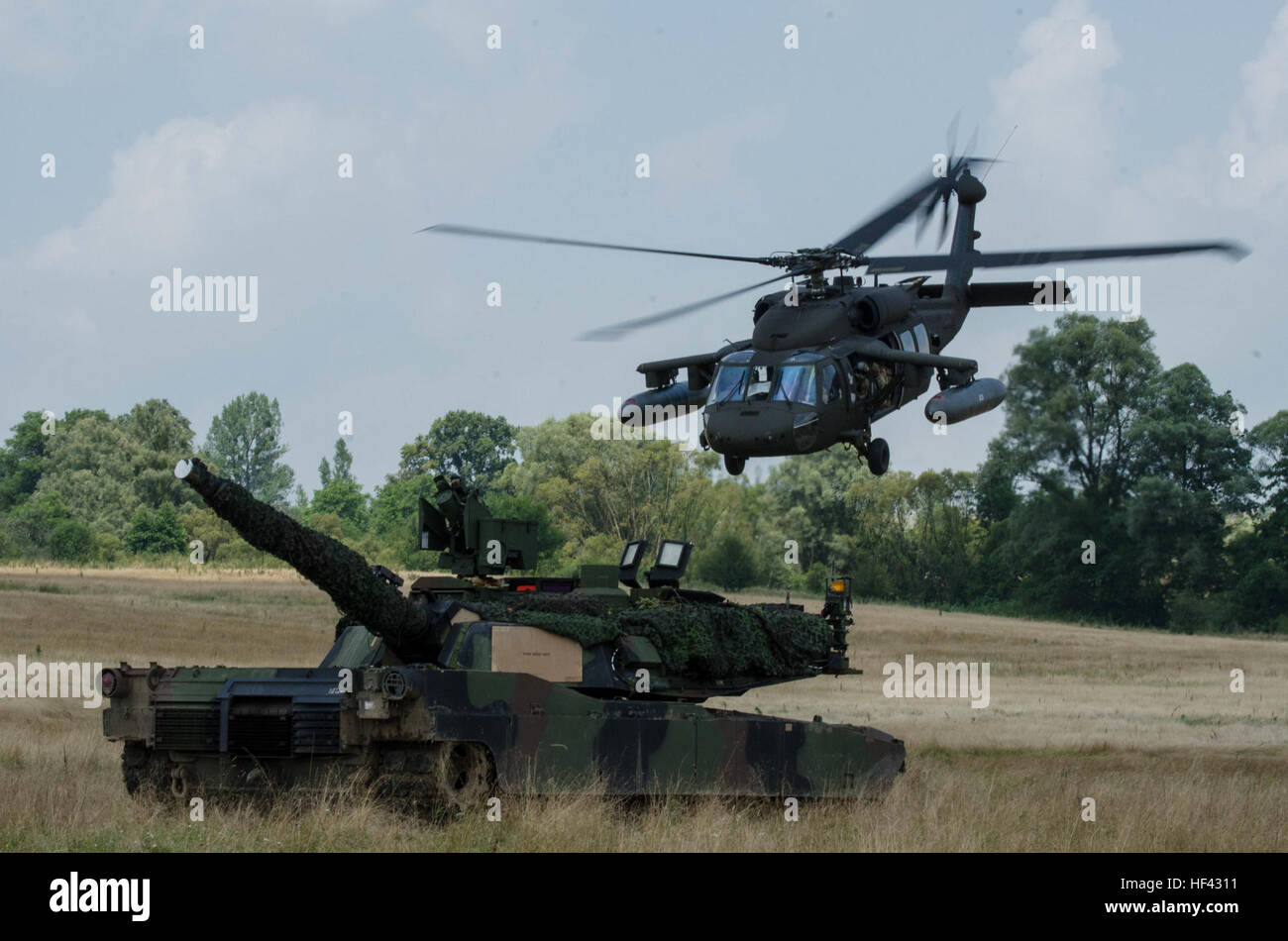 Un UH-60 Blackhawk elicottero con la società C, 3° Battaglione, 501Reggimento di aviazione da Ft. Bliss, Texas, vola su un M1A2 Abrams con sede e Sede Società, 1° Battaglione, 64th Armor reggimento da Ft. Stewart, Georgia il 30 luglio durante la Saber custode di esercizio che ha avuto luogo presso il rumeno di forze terrestri Combat Training Center in Cincu, Romania. Saber Guardian è come un militare multinazionale di esercizio di circa 2.800 militari provenienti da dieci nazioni tra cui l'Armenia, Azerbaigian, Bulgaria, Canada, Georgia, Moldavia, Polonia, Romania, Ucraina e Stati Uniti (U.S. Foto Stock