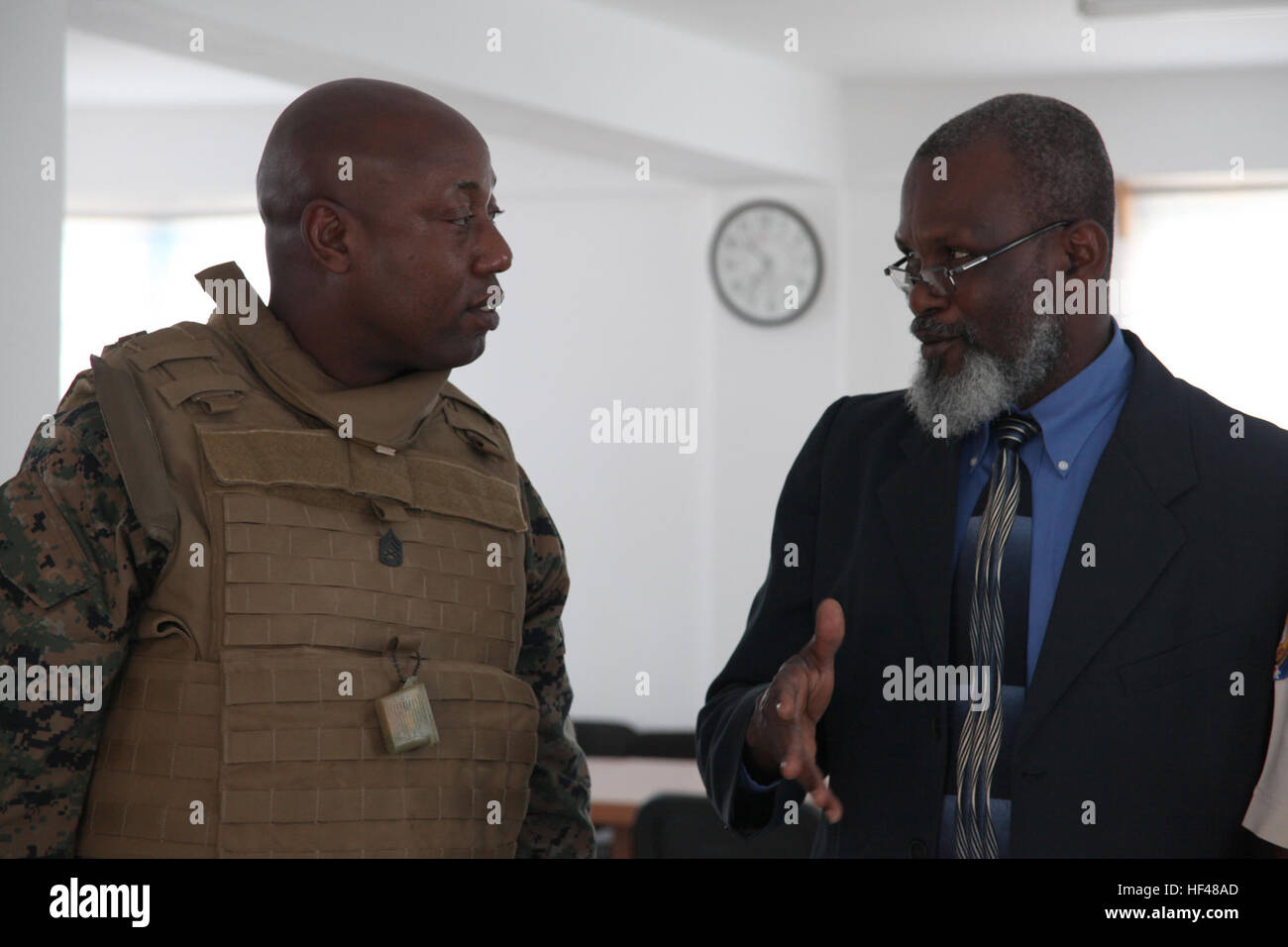 Gunnery Sgt. Felder Domond, nativo di Port-au-Prince, Haiti, parla con Guillet Salvador, sindaco di Port-de-Paix, Haiti, circa le missioni che saranno condotte in Haiti, 24 luglio. Salvador e Haiti la Polizia Nazionale ha portato Marines e marinai a vari siti di missione di Port-de-Paix in preparazione per il personale militare e non i funzionari del governo di condurre umanitario assistenza civica come parte dell'operazione continua promessa 2010. USS Iwo Jima Marines, marinai di iniziare la distribuzione sul suolo haitiano DVIDS303361 Foto Stock