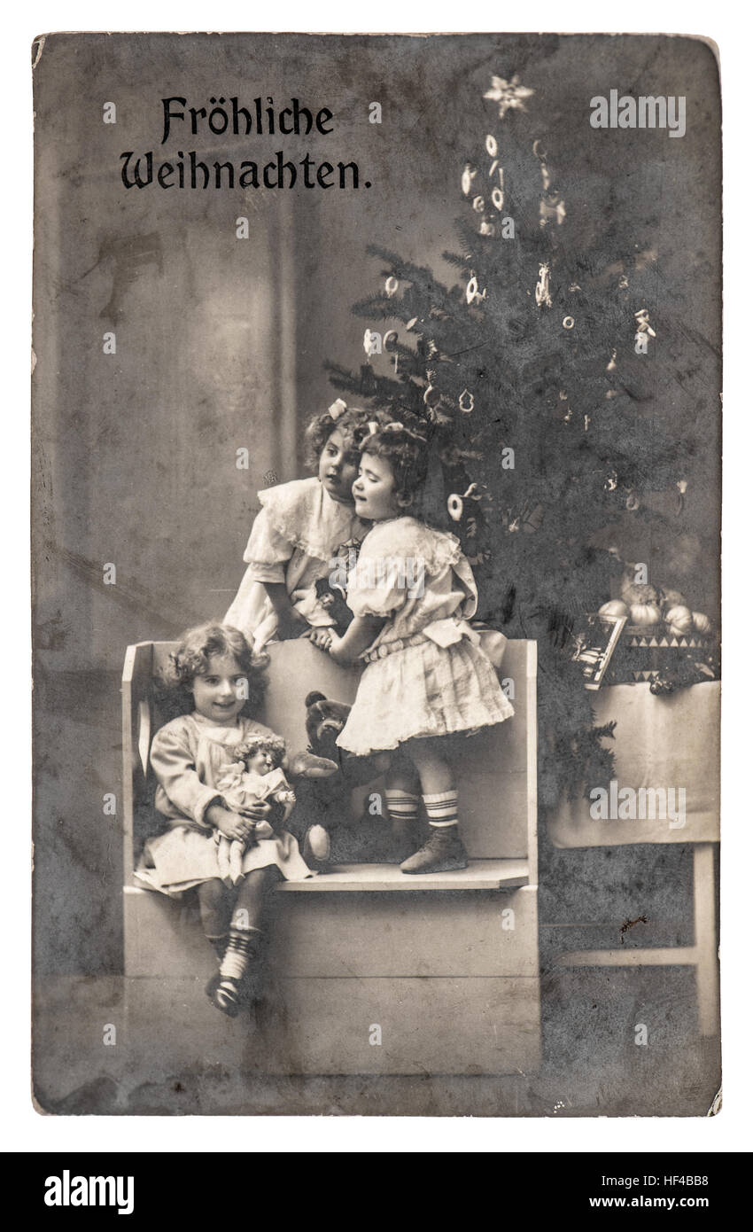 Felici i bambini con l'albero di Natale, regali e giocattoli d'epoca. Antica immagine seppia con pellicola originale del grano e la sfocatura Foto Stock