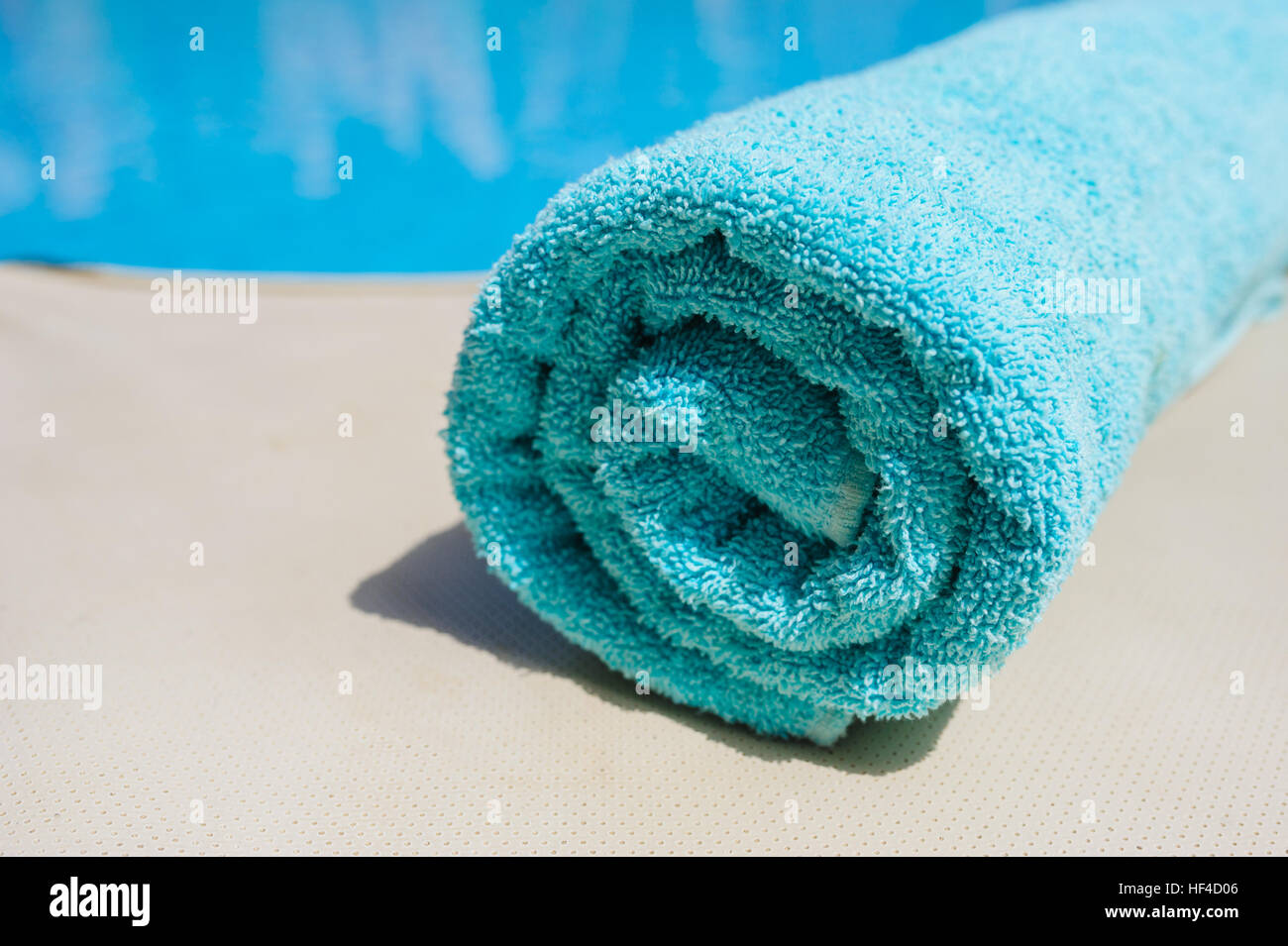 Il turchese asciugamano giace sul bordo della piscina Foto Stock