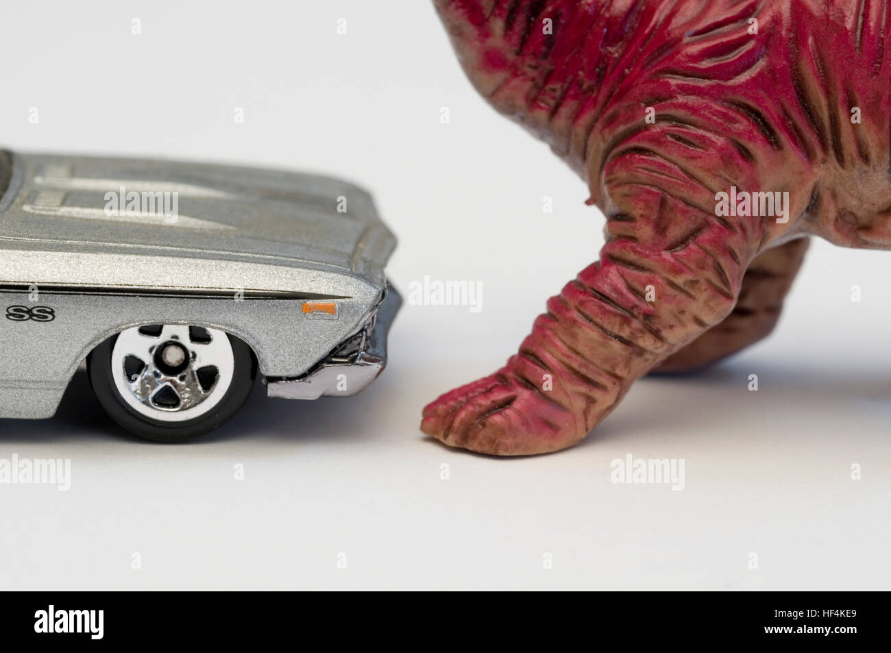 Modello di auto rivolta verso il giocattolo dinosauro Foto Stock