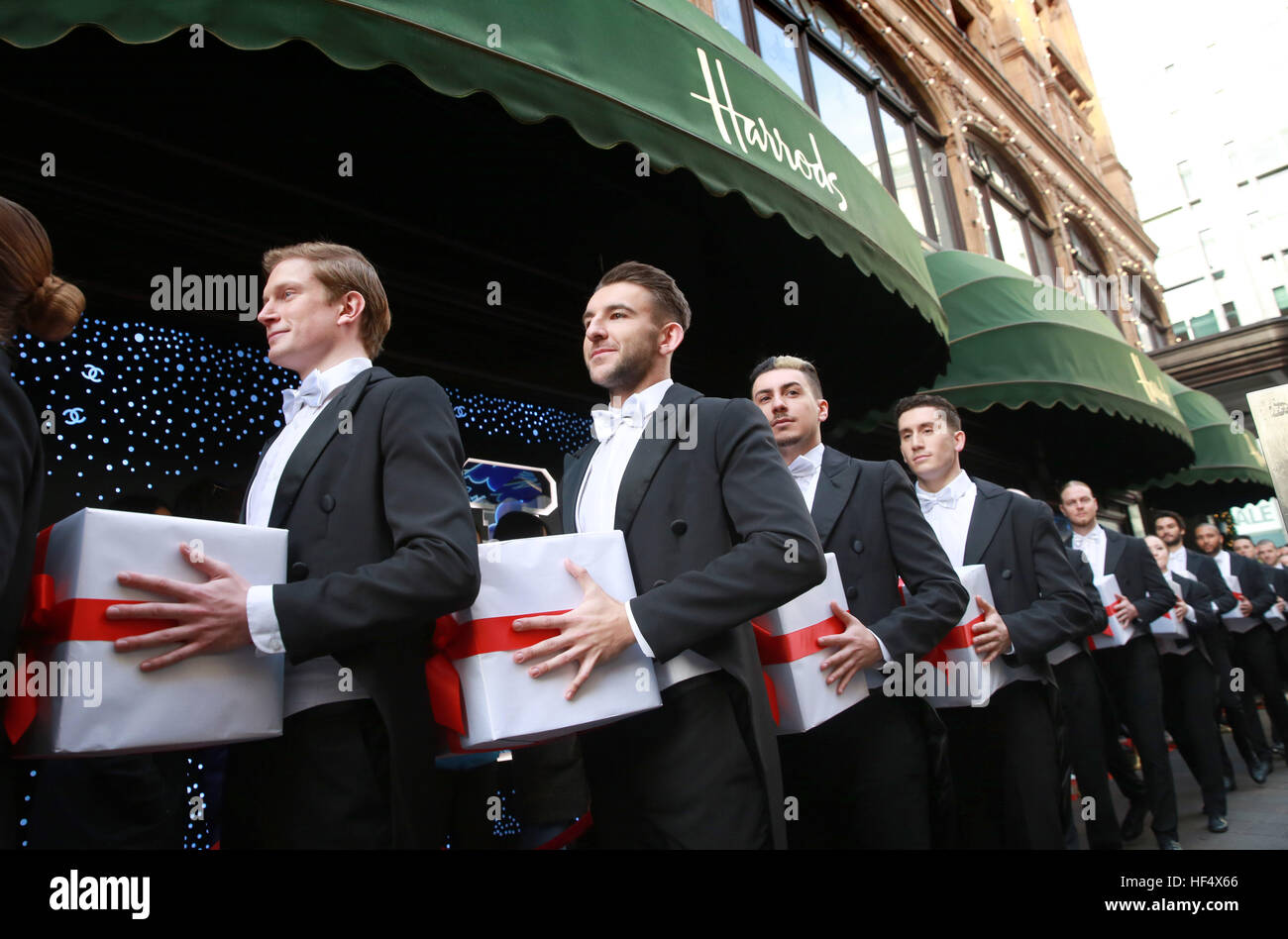 I maggiordomi di Harrods sono sorpresi all'apertura della vendita invernale di Harrods a Knightsbridge, Londra, con una spettacolare performance di ballo tap. Foto Stock
