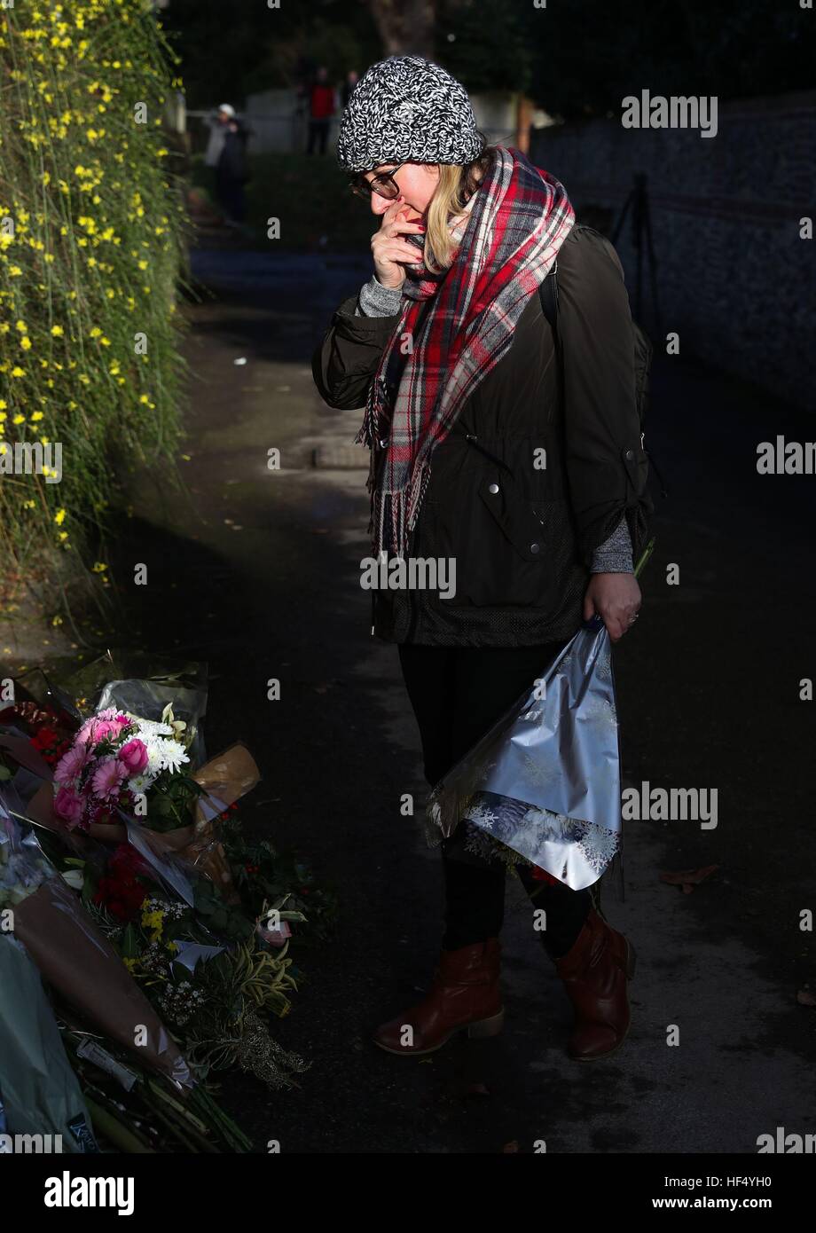 Una signora guarda di omaggi floreali che sono state lasciate al di fuori del Goring casa di George Michael in Oxfordshire come la superstar pop è morto all età di 53 dal sospetto di insufficienza cardiaca. Foto Stock