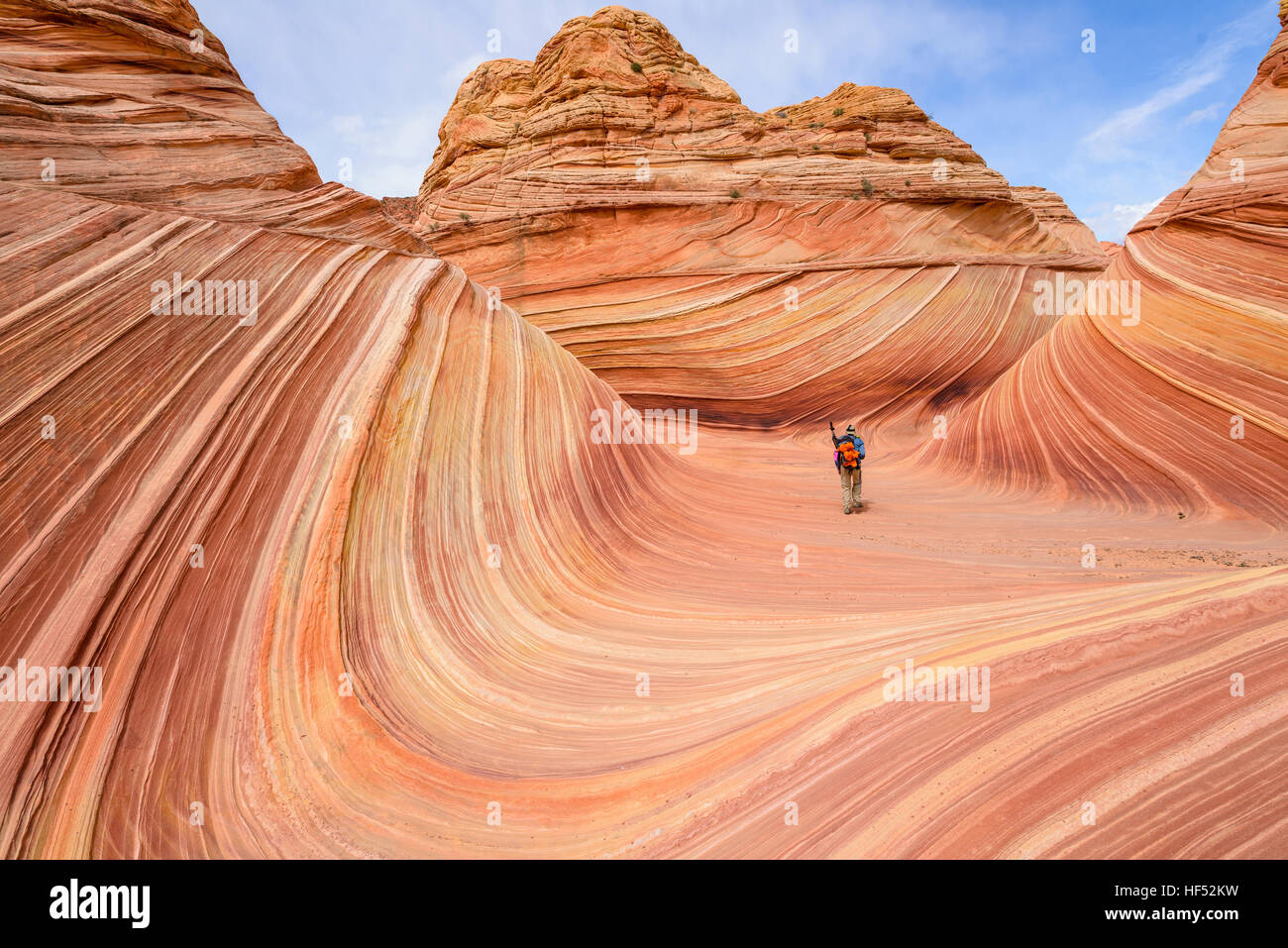 Passeggiate in onda - di un ben attrezzato gli escursionisti a piedi attraverso il centro della forma d'onda su una soleggiata giornata di primavera. Arizona-Utah, STATI UNITI D'AMERICA. Foto Stock