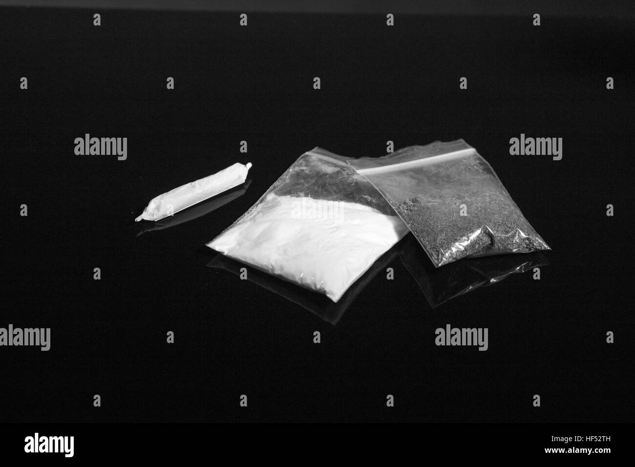 Confezioni di narcotici e comune di marijuana su sfondo nero, bianco e nero Foto Stock