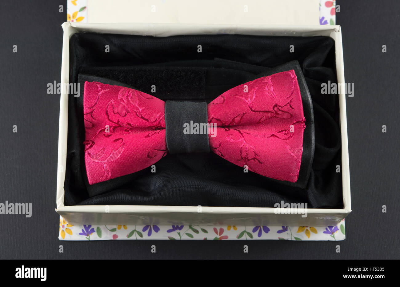 Red bow tie in un presente casella su sfondo nero Foto Stock