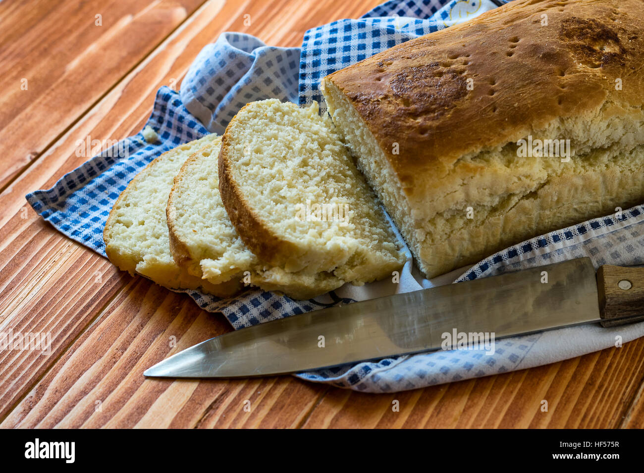 Fette di pane fatto in casa su un tavolo di legno con un coltello Foto Stock