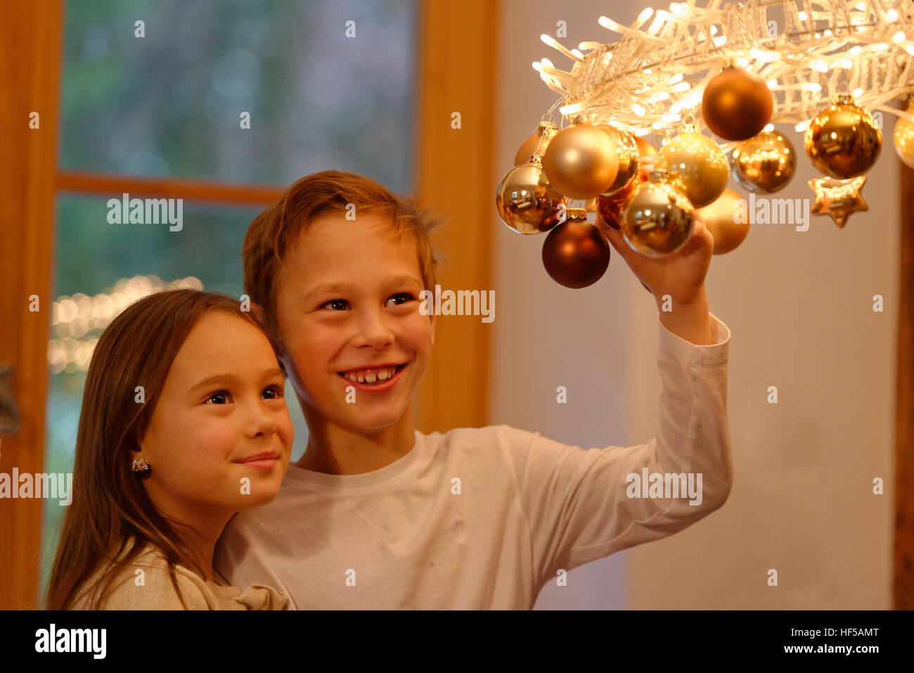 Bambini, ragazzo e una ragazza con luci e la ghirlanda decorazione di Natale, anticipazione del Natale, Alta Baviera, Baviera, Germania Foto Stock