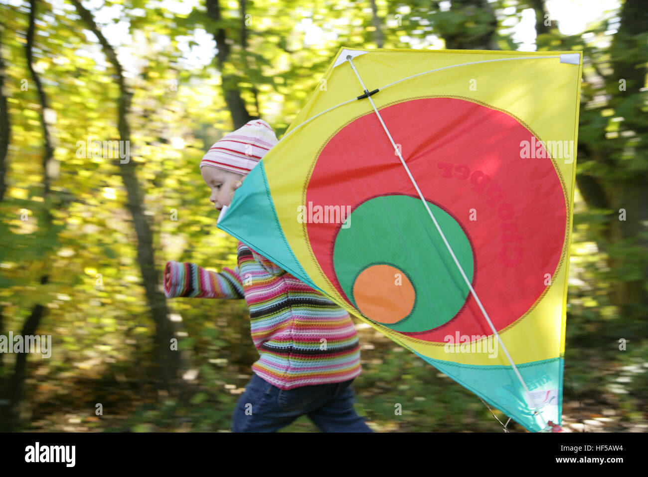 Tre-anno-vecchia ragazza che gioca con kite Foto Stock